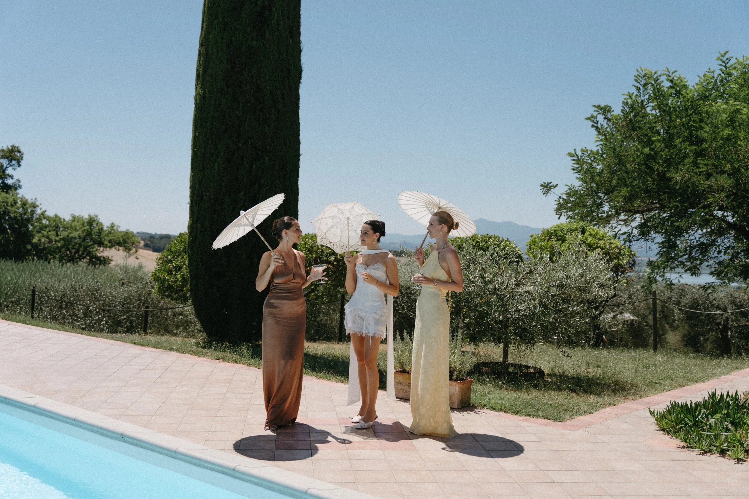 bridal party having pre-wedding drinks next to the pool at villa cozzano