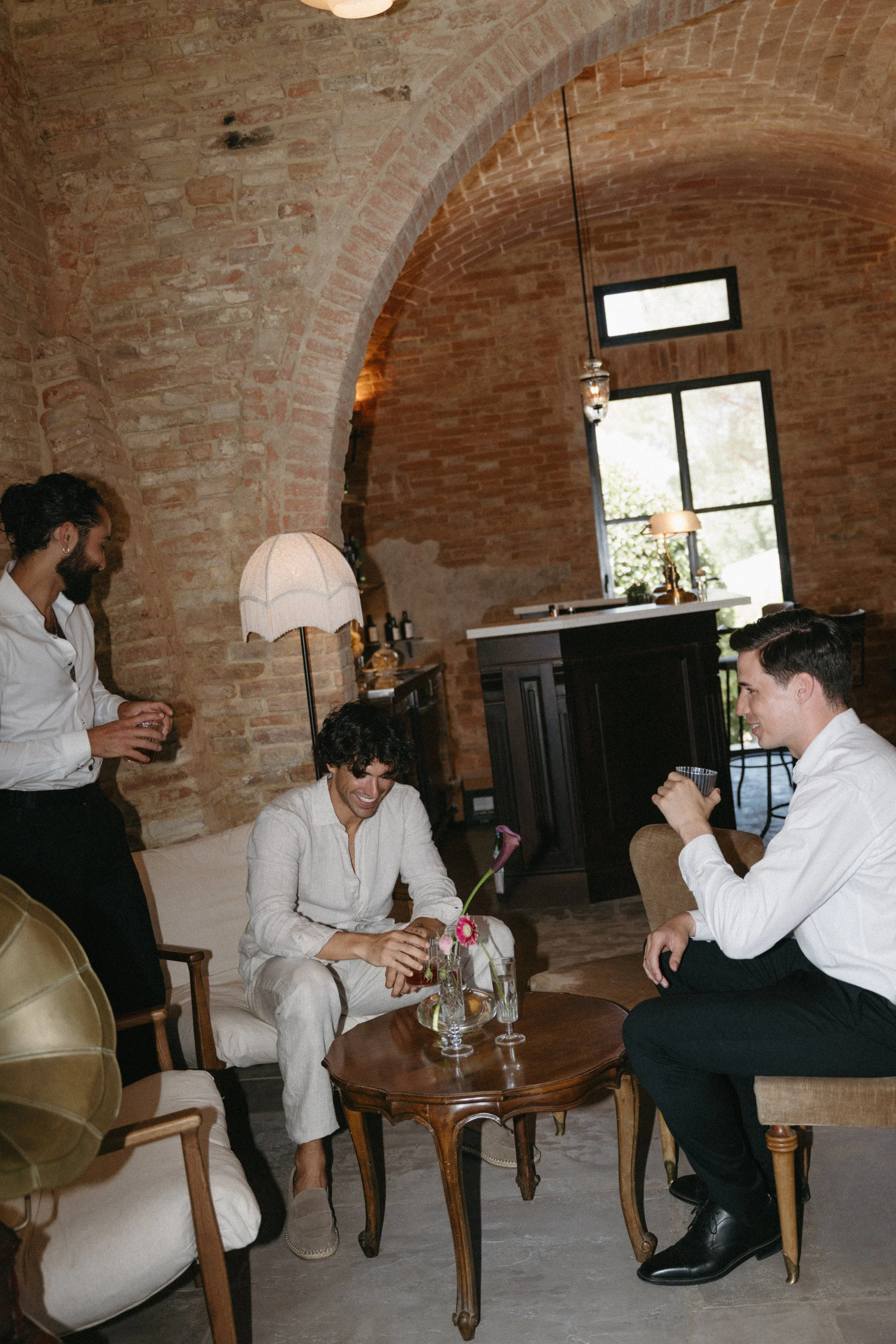 Groom relaxing with groomsmen at Villa Cozzano Tuscany destination wedding