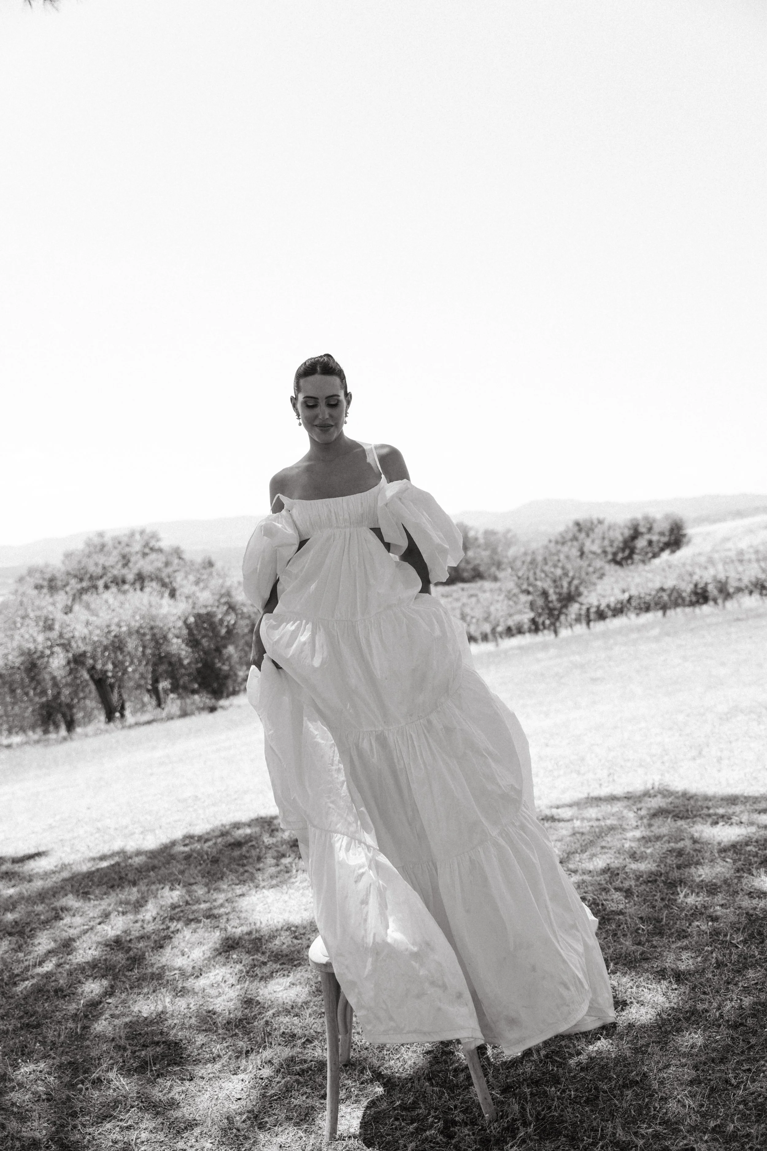 Bride in billowing white tiered dress with off-the-shoulder sleeves during Tuscany wedding editorial at Villa Cozzano