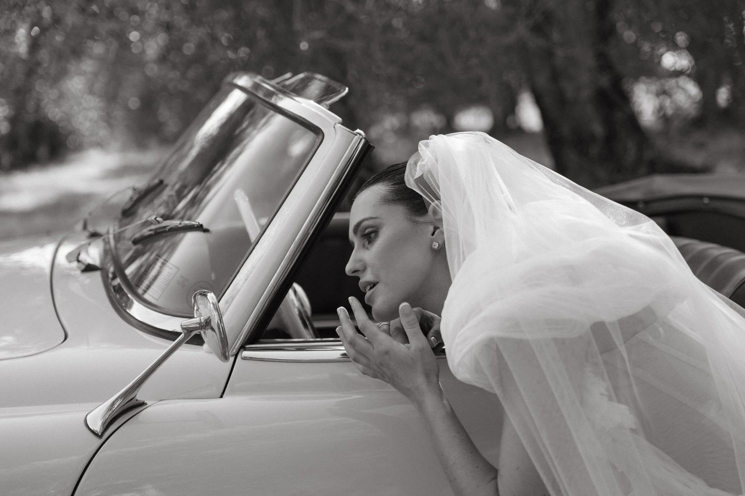 bride fixing makeup in car window at Villa Cozzano Tuscany wedding editorial