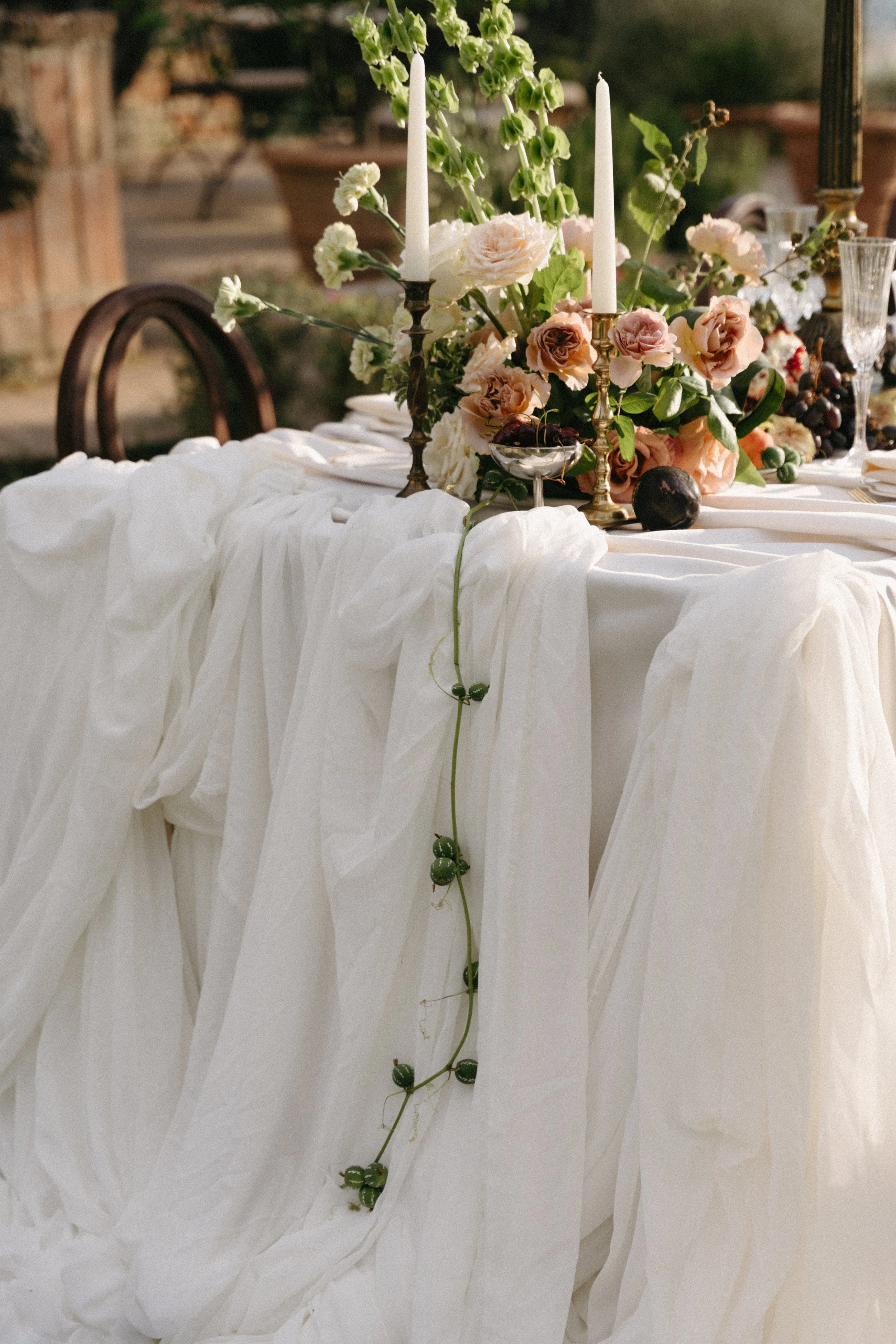 Micro wedding dining tables with soft candlelight and romantic Tuscan villa backdrop