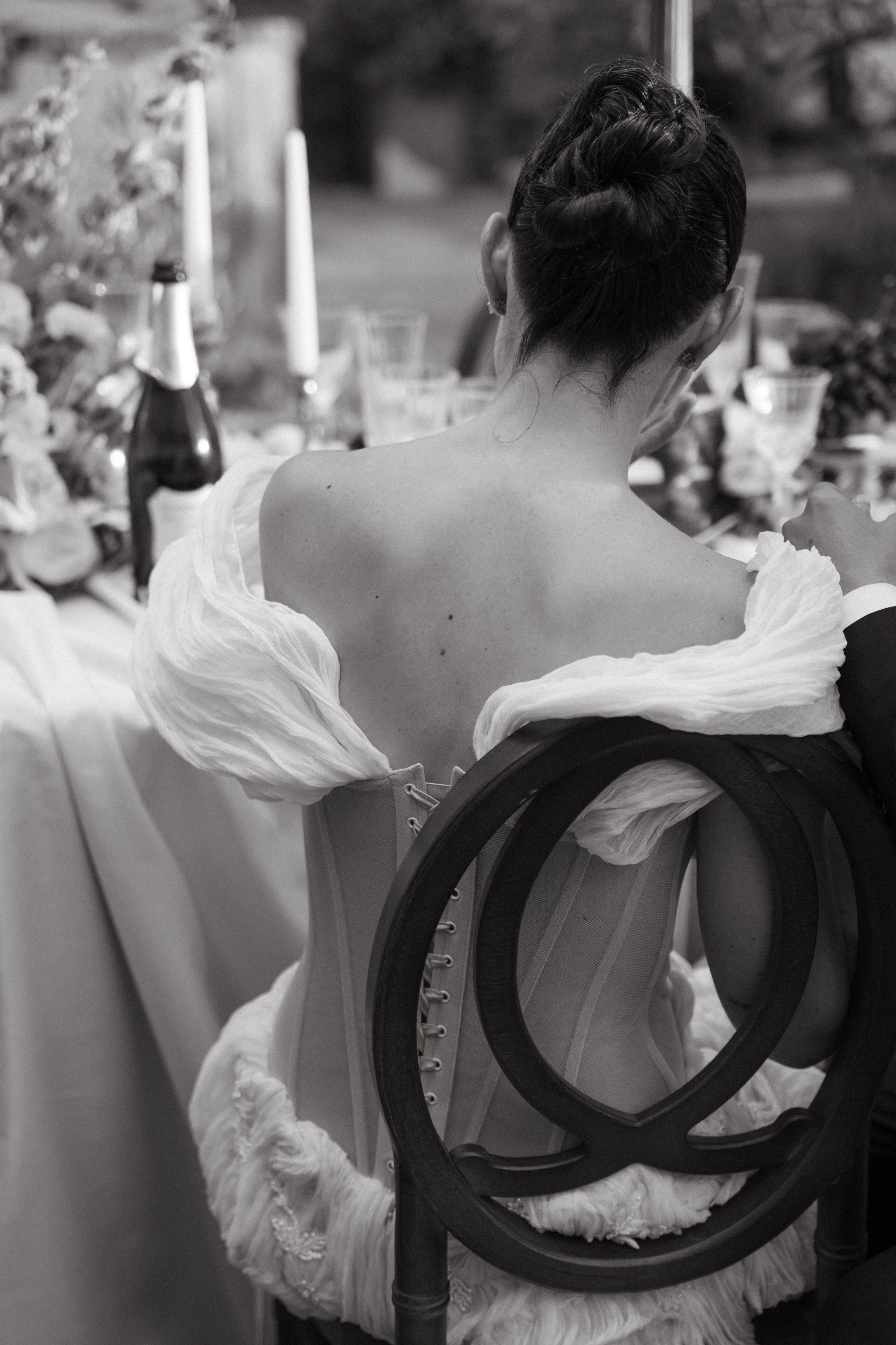 Bride sitting in elegant off-the-shoulder gown during Tuscany editorial wedding portraits