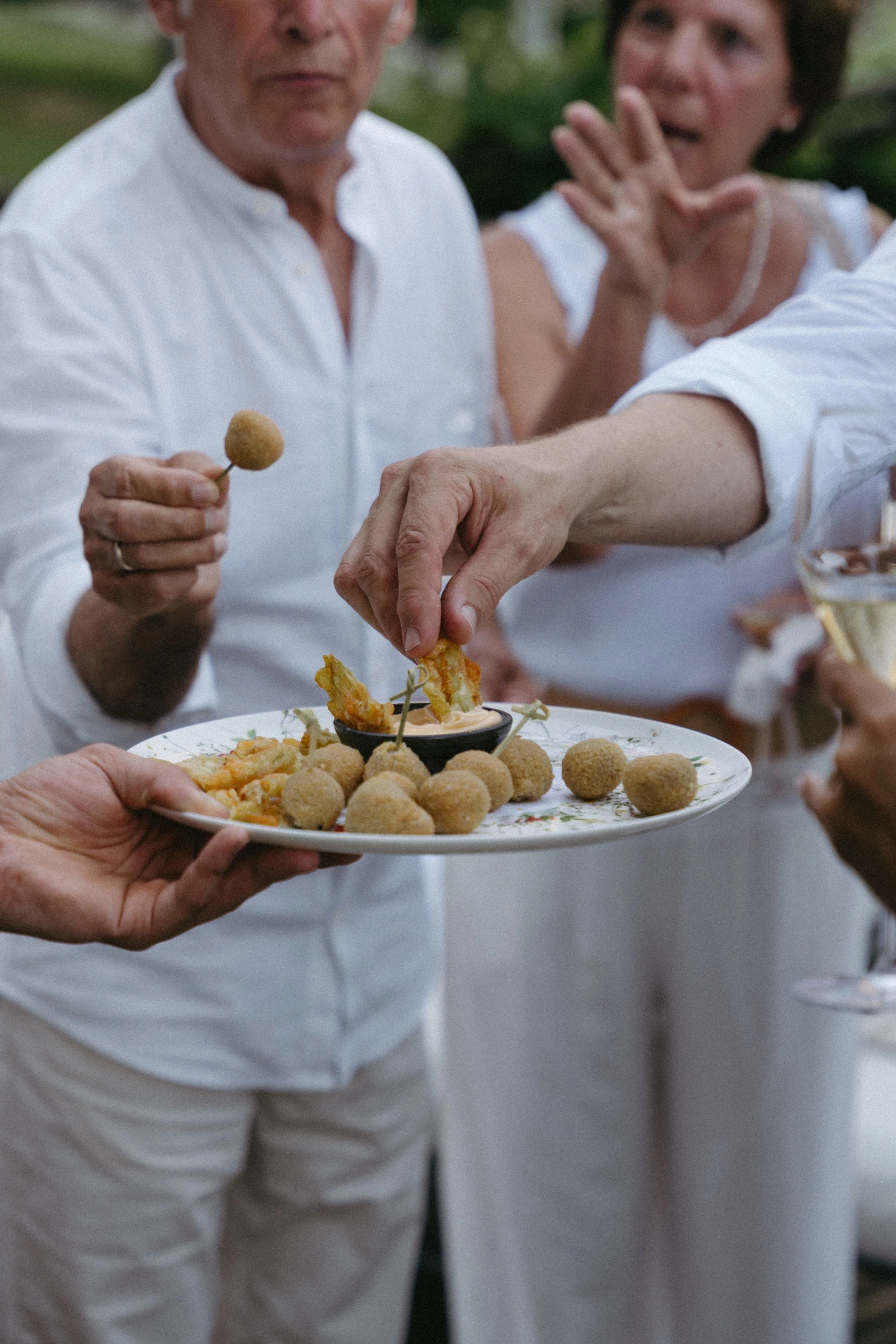 guests enjoying canapes at the couple's white welcome dinner at Ristorante Da Enzo in Tegna, Switzerland