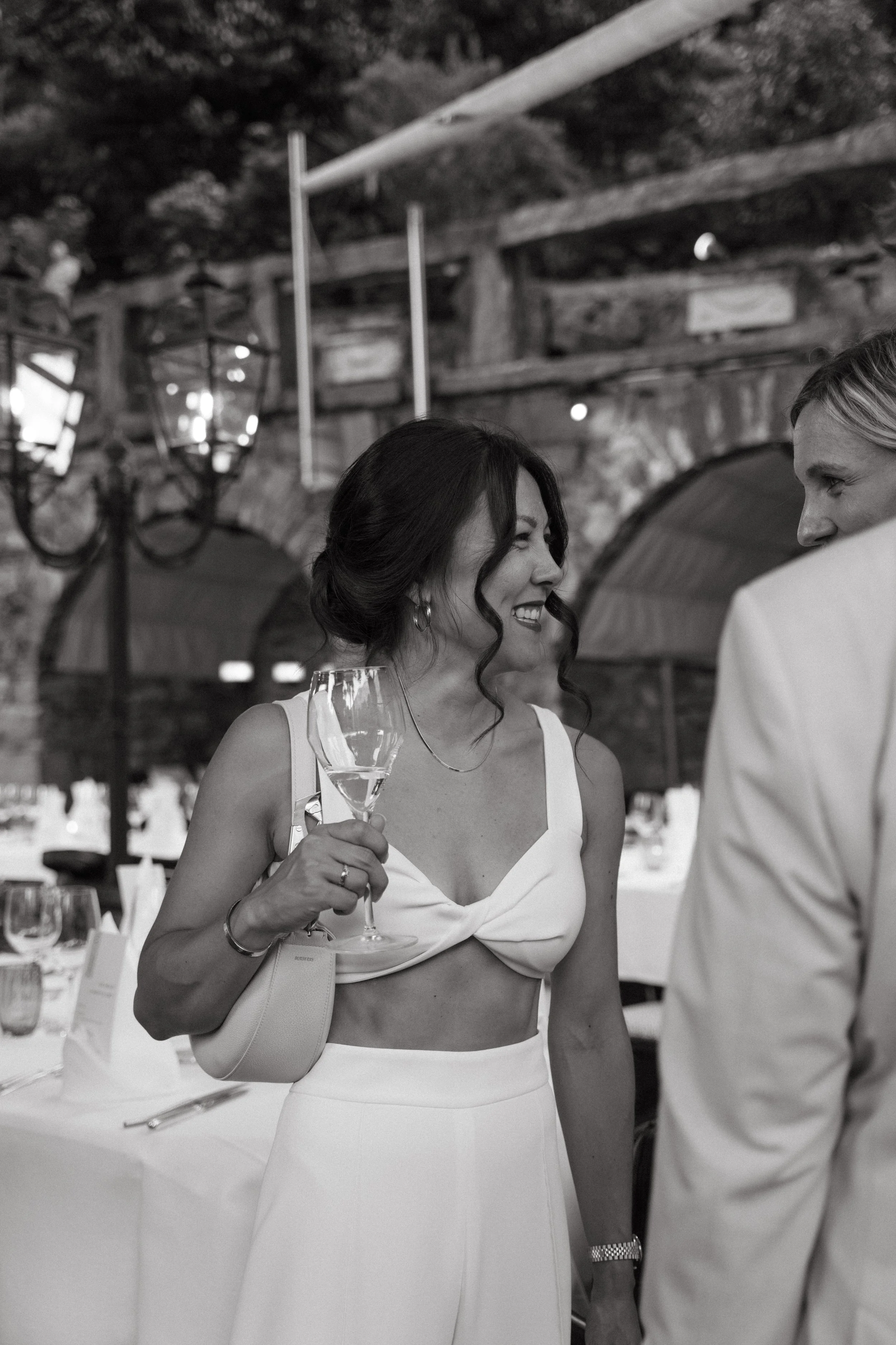 bride enjoying a candid conversation with welcome dinner guest 