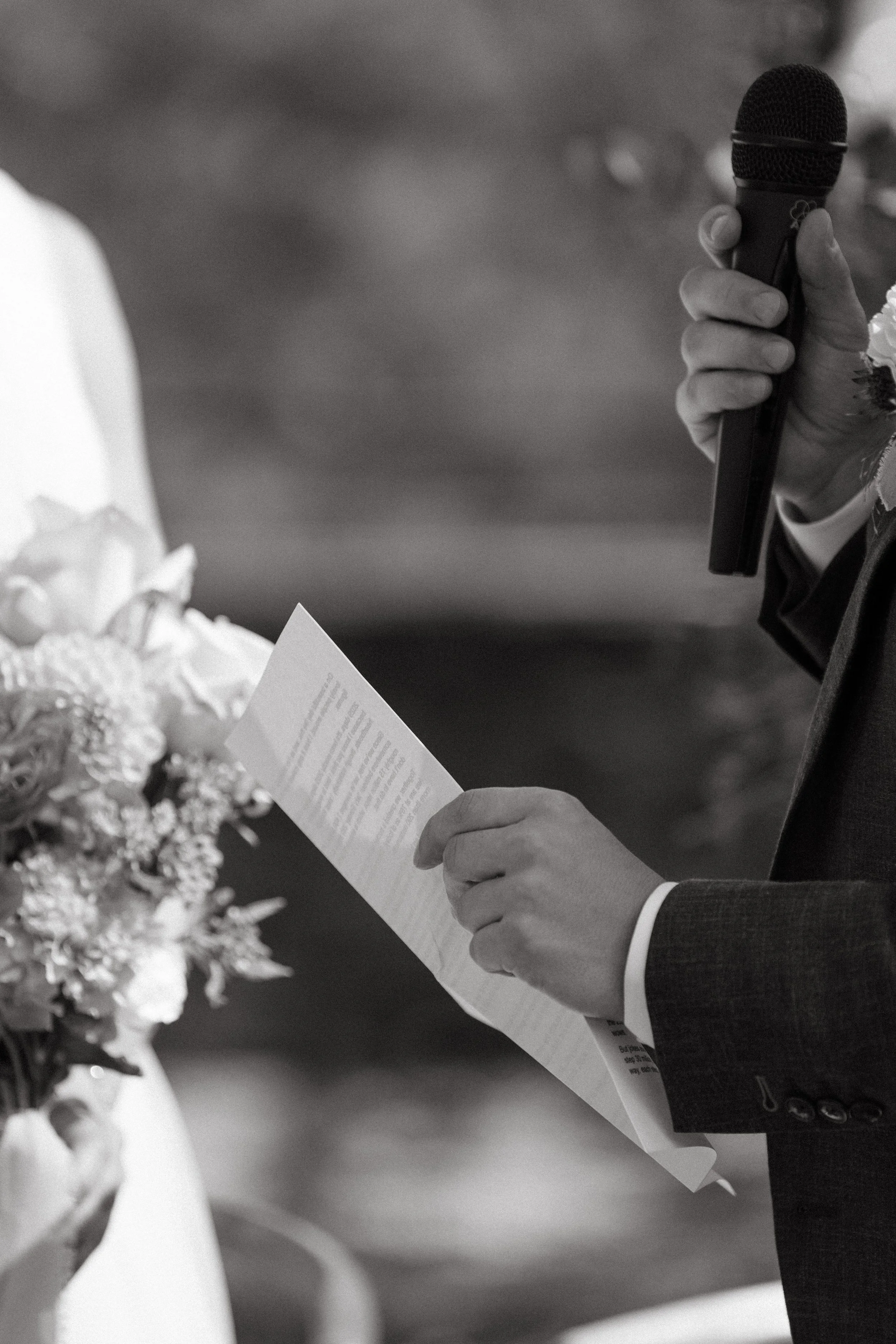 shot of groom holding his vows during intimate outdoor wedding ceremony at Villa San Quirico 