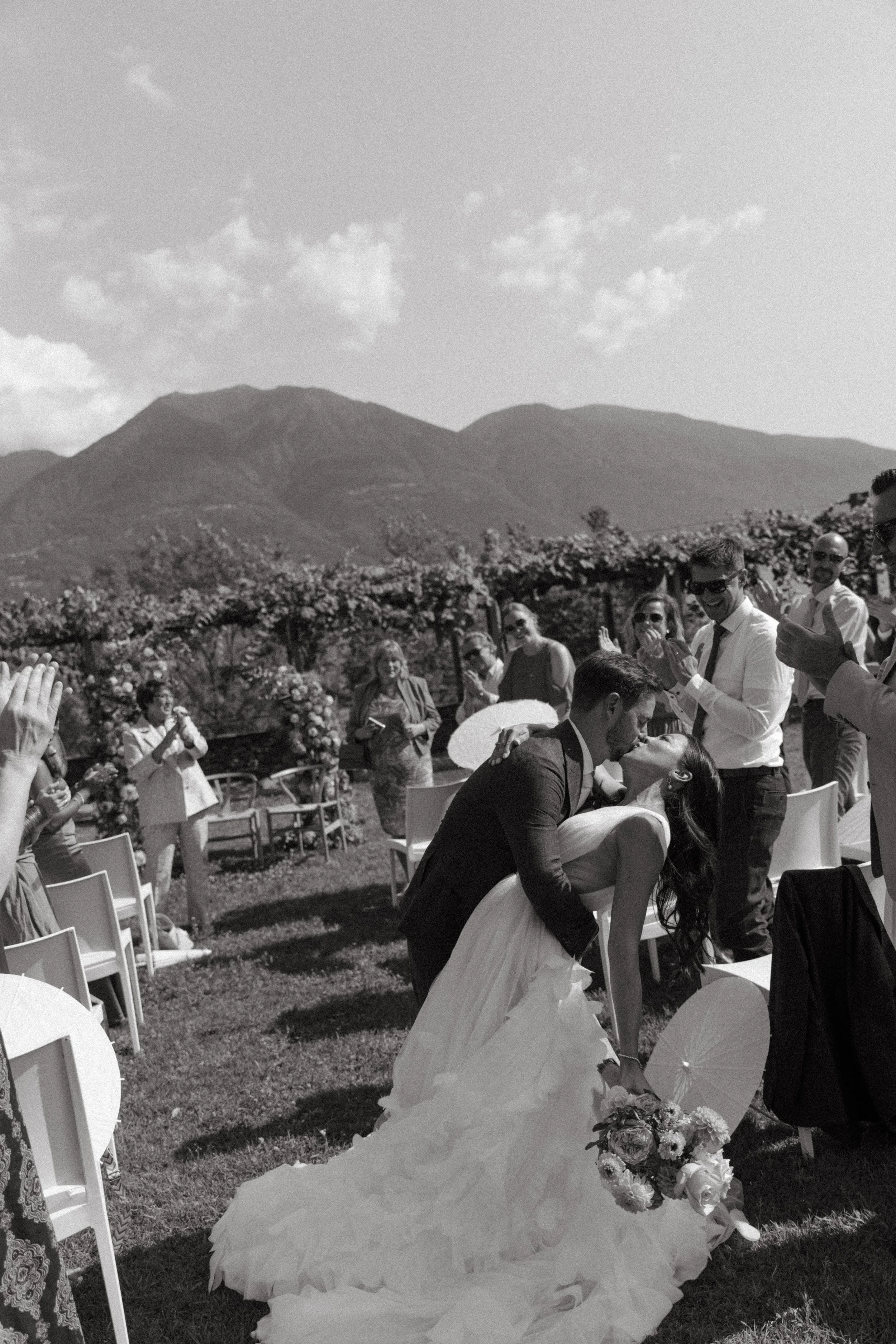 guests applauding as the couple share a kiss as they walk back down the aisle