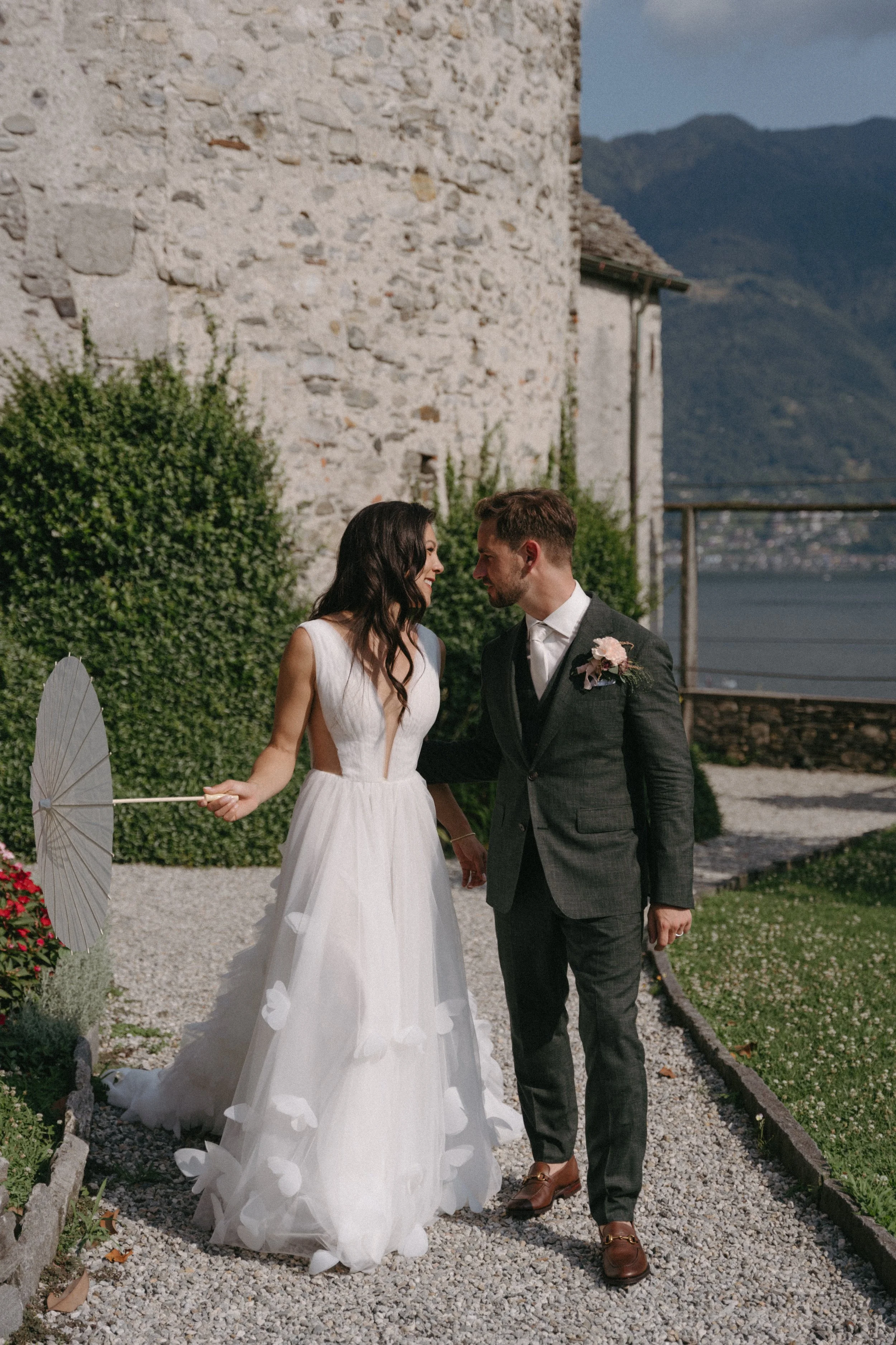 Newlyweds walking hand in hand through the lush villa gardens in Minusio, Switzerland