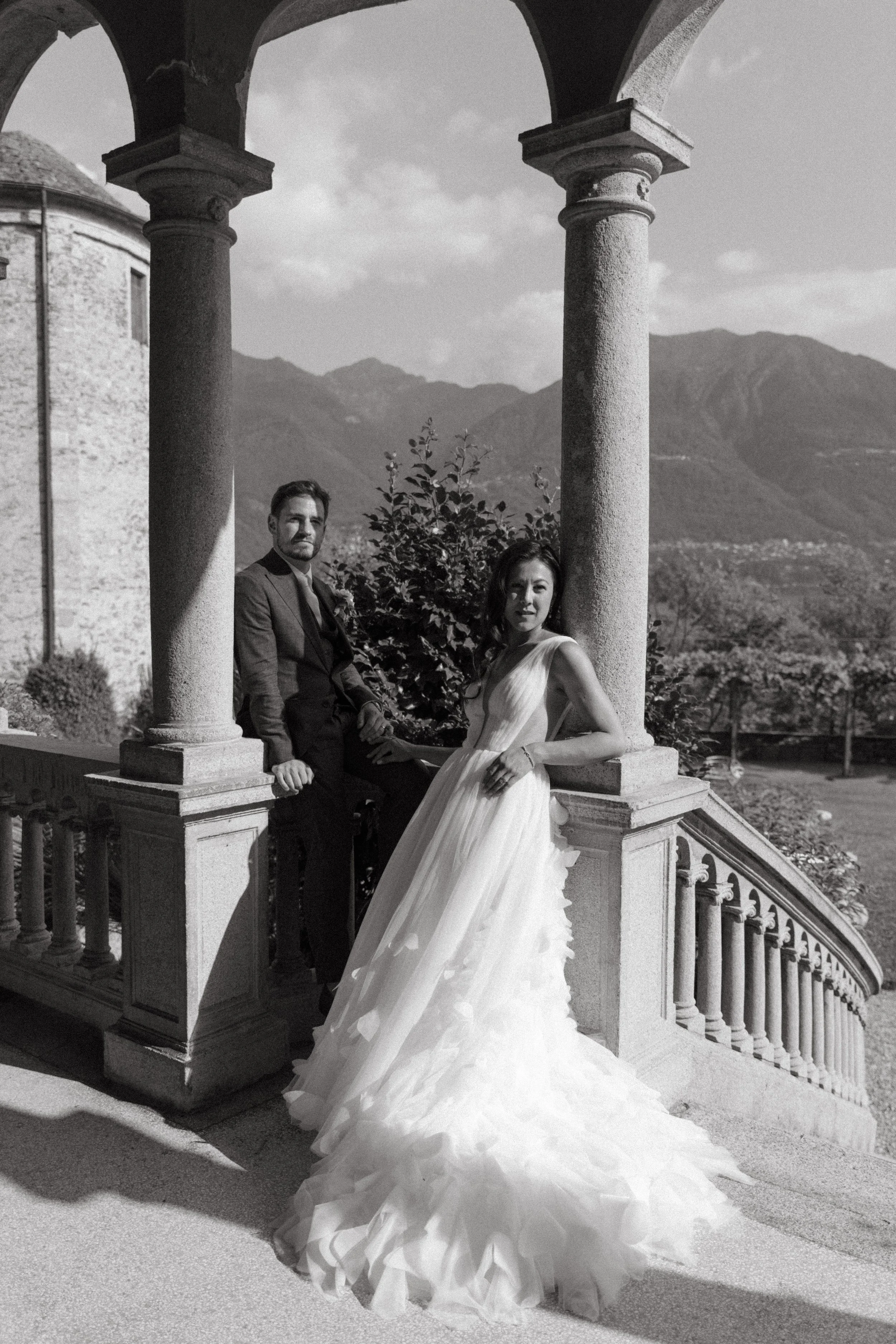 Timeless black and white portrait of the couple framed by villa arches