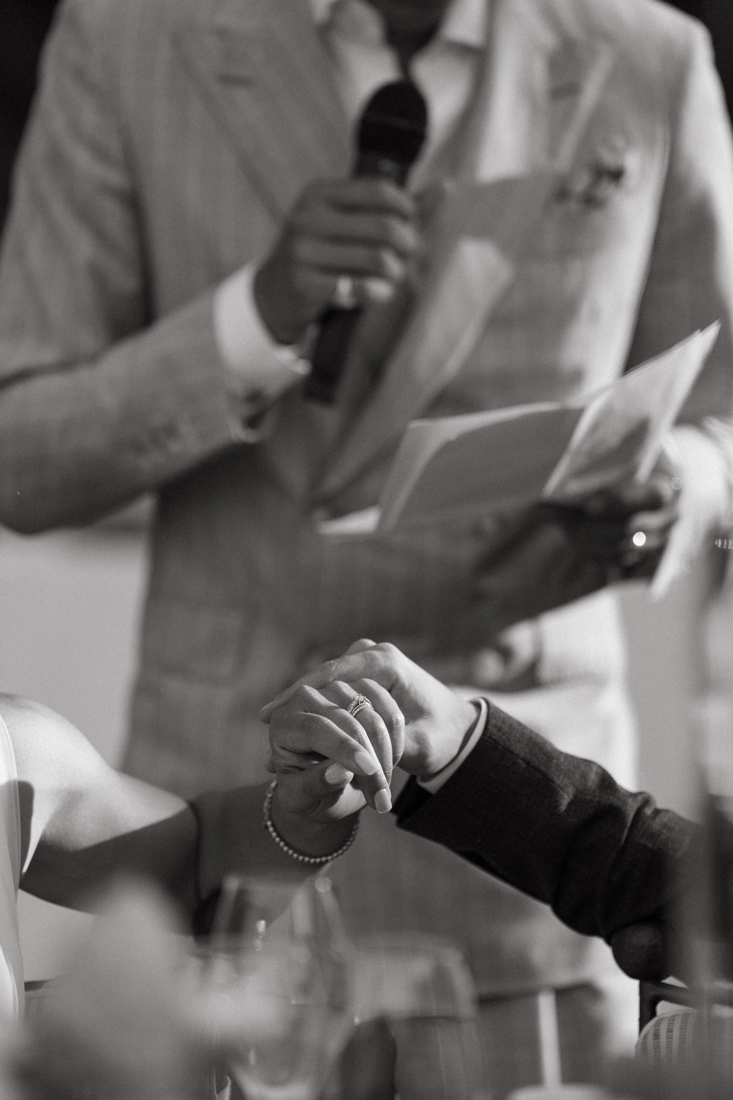 black and white film portrait of couple holding hands during their intimate wedding reception in switzerland
