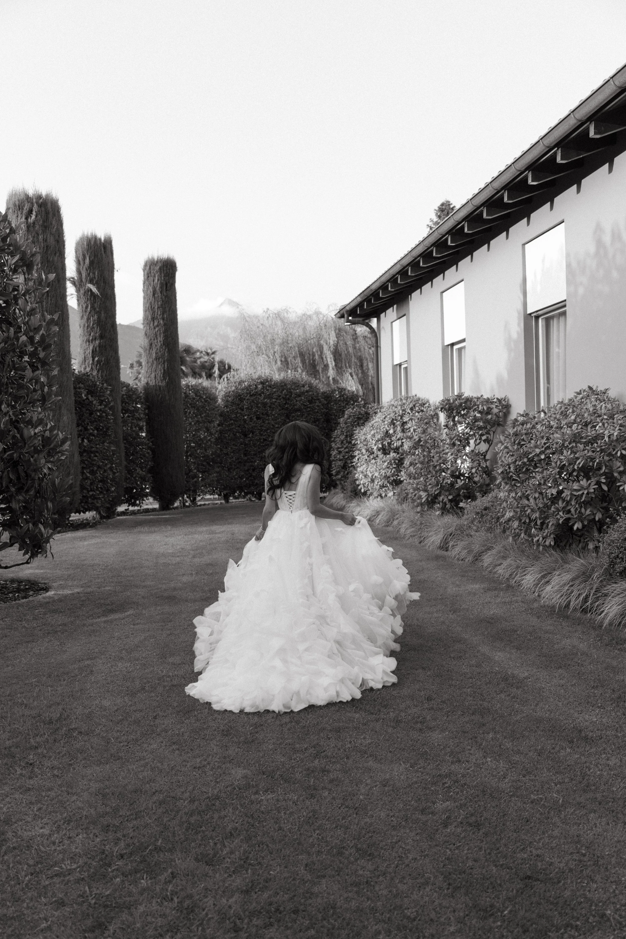 black and white portrait of bride with her back turned in the garden