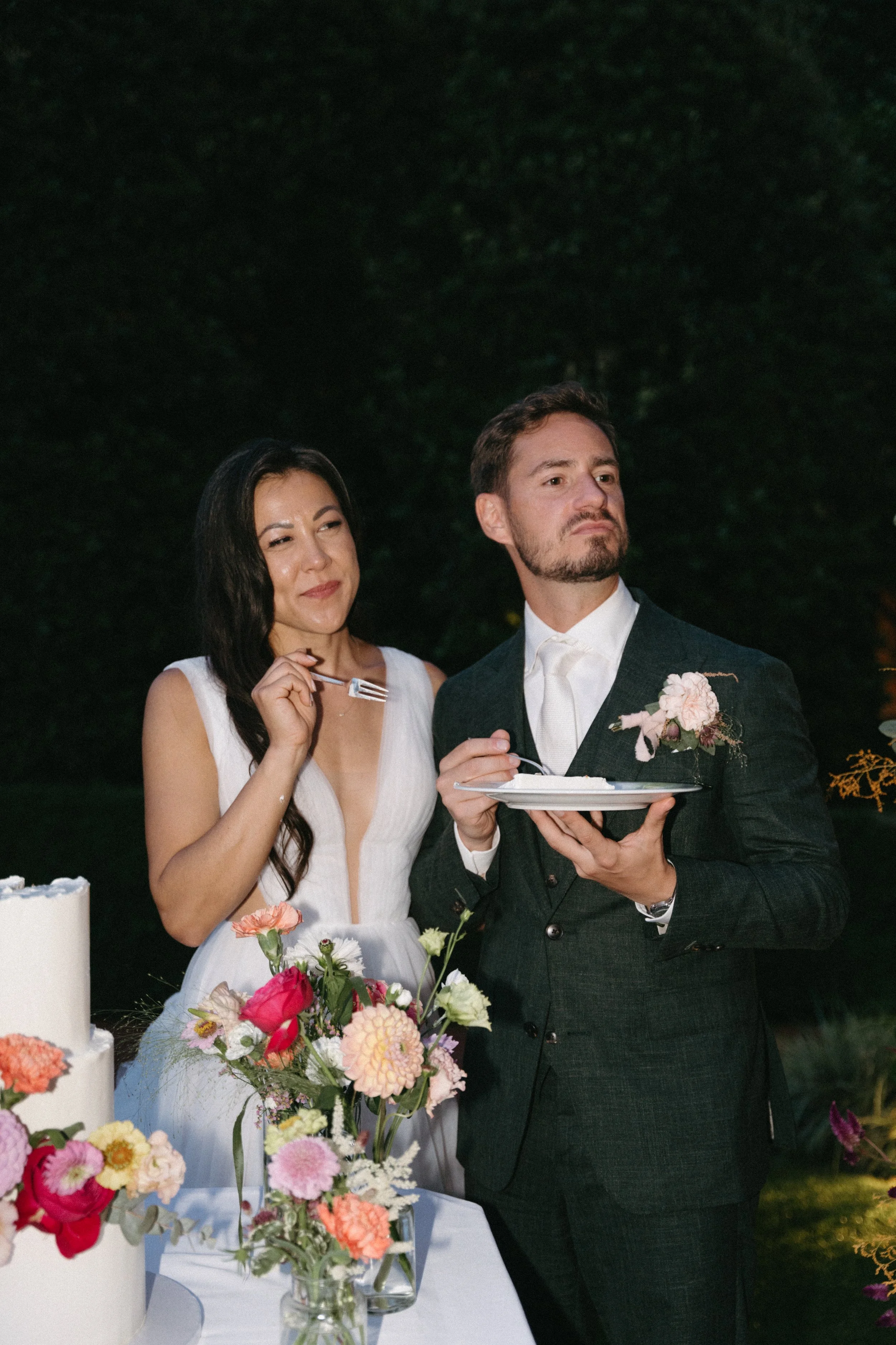 portrait of bride and groom enjoying a slice of their wedding cake