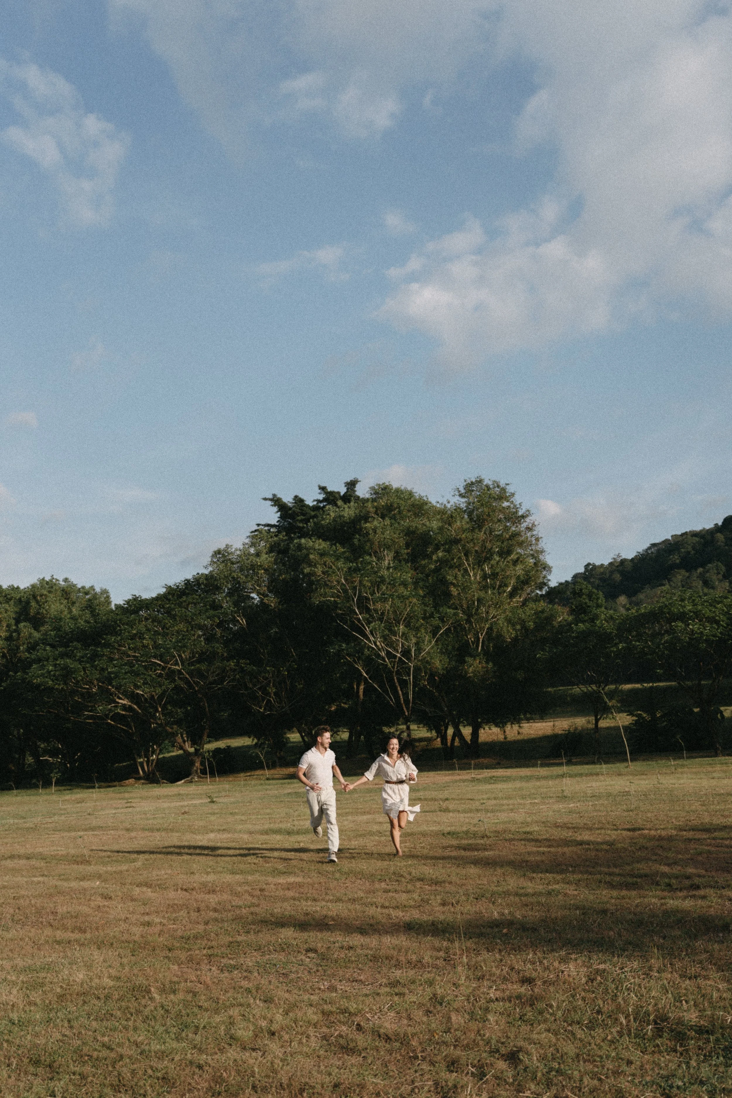 cinematic portrait of couple running hand in hand during couples photoshoot at Koh Kaew Lake