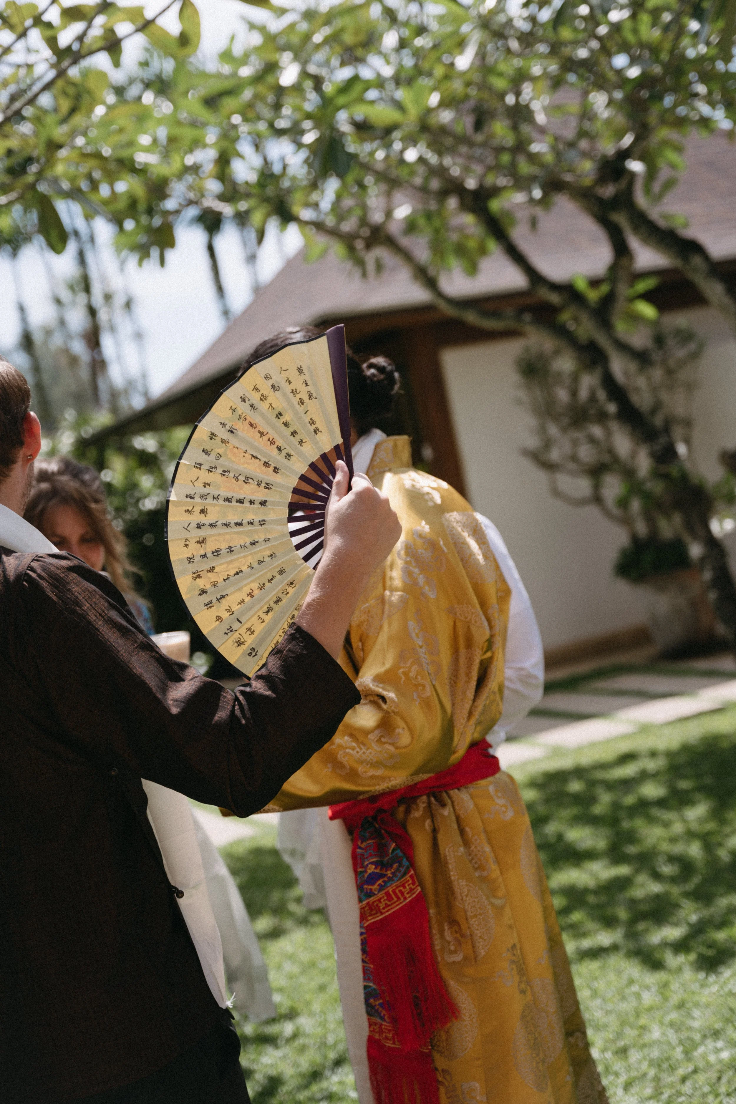 guest holding a traditional chinese fan 