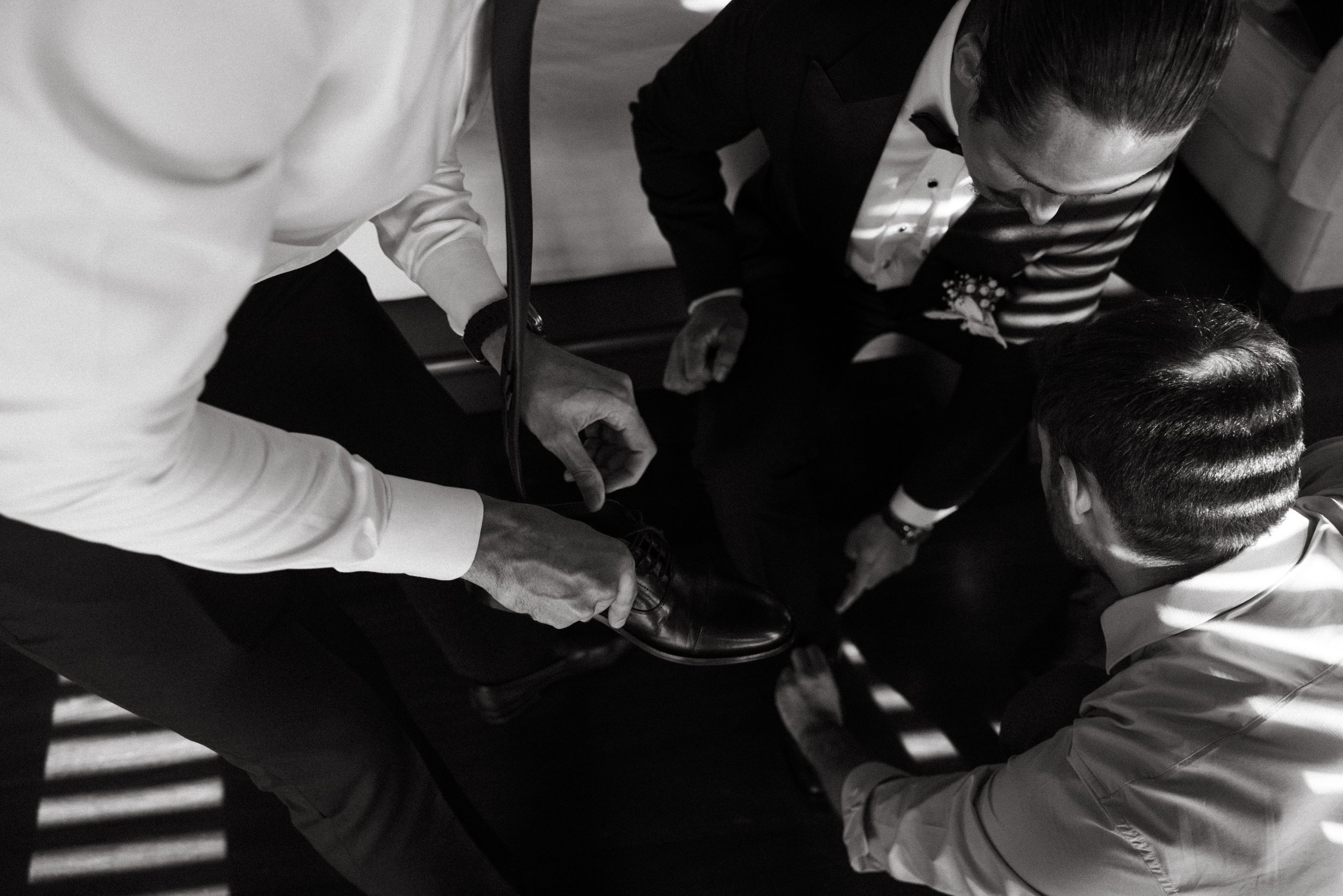groomsmen helping groom get ready for the western ceremony