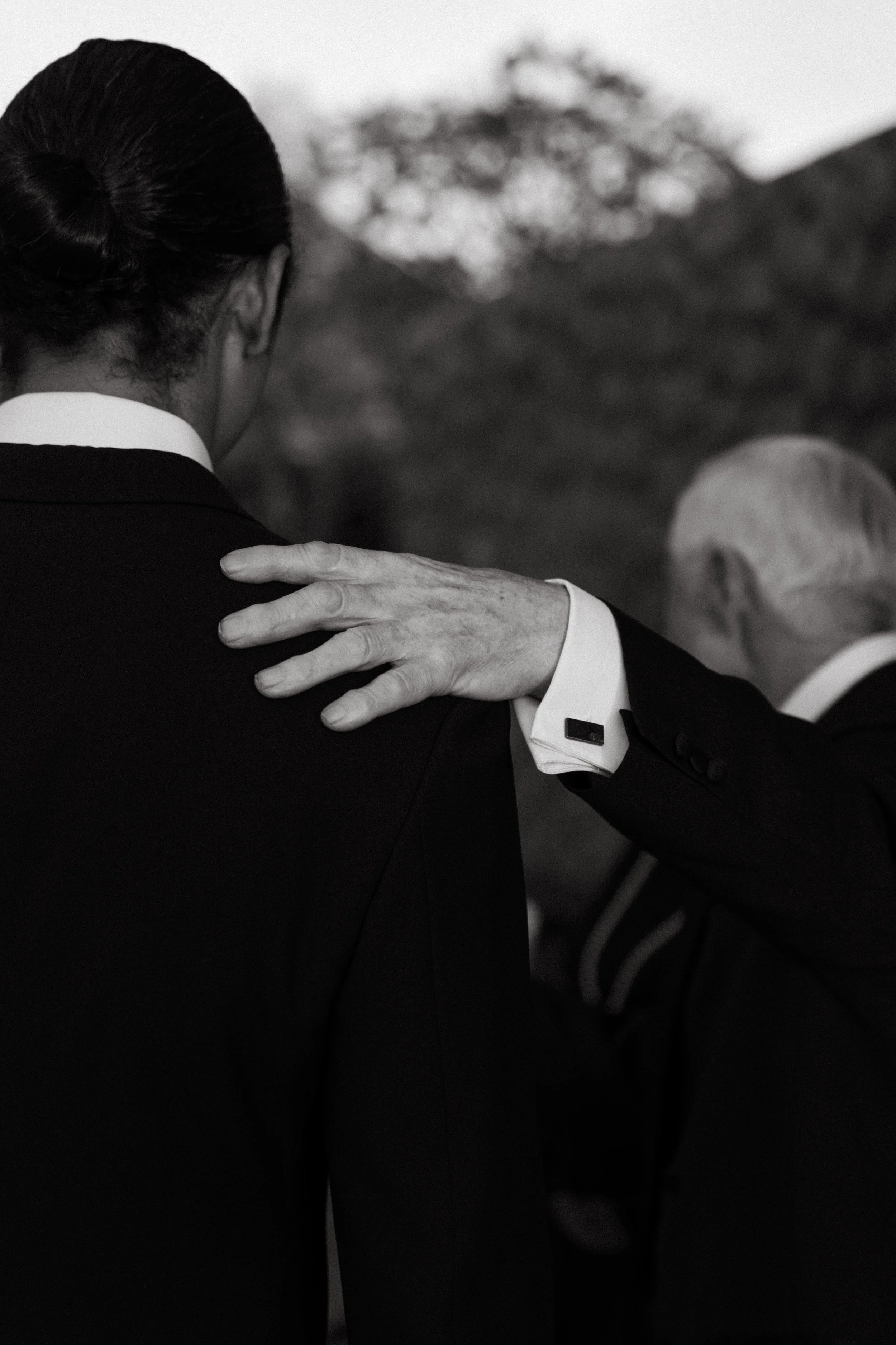 close up shot of groom's father patting him on the shoulder