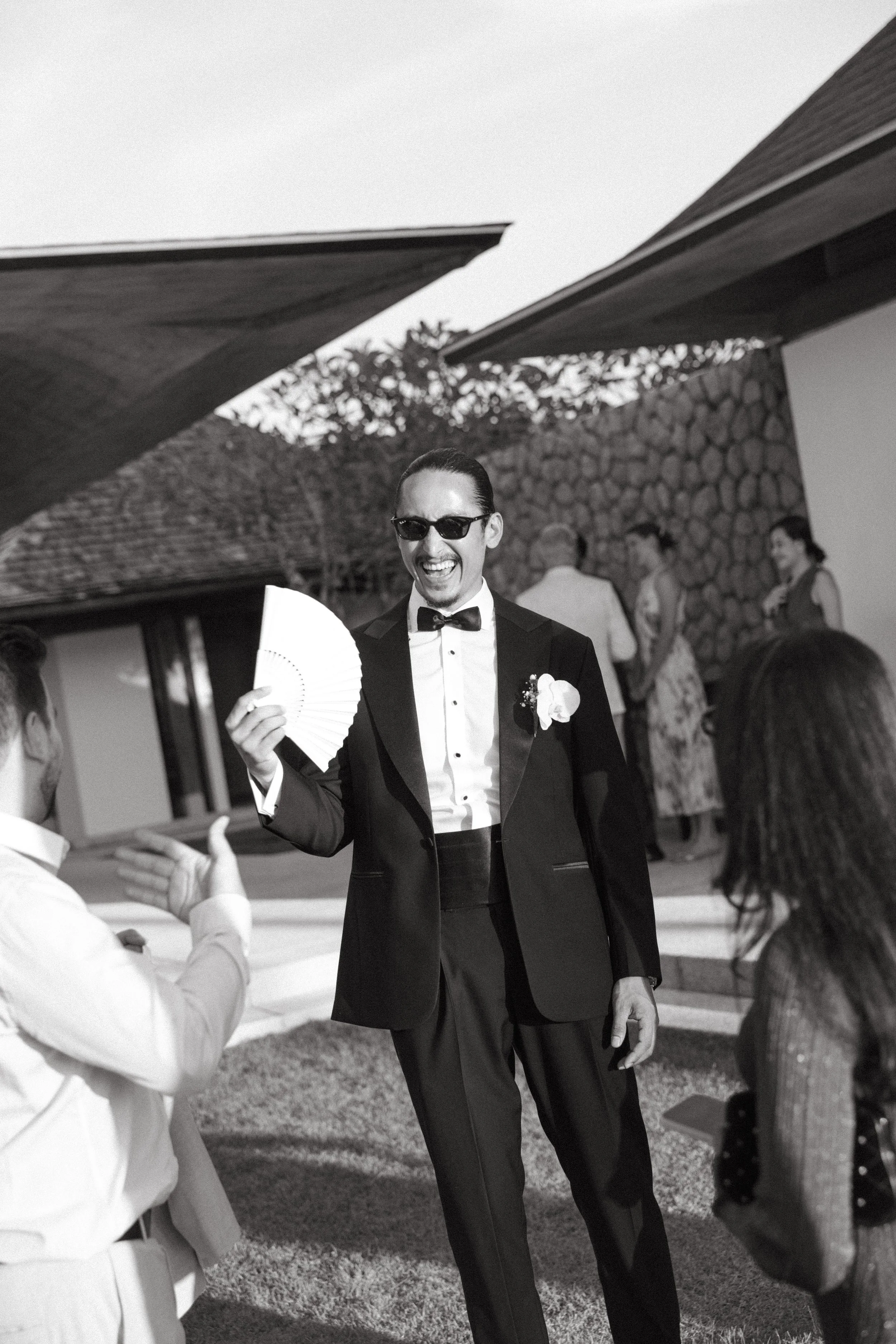 groom laughing and fanning himself as he greets guests arriving at jivana beach villas