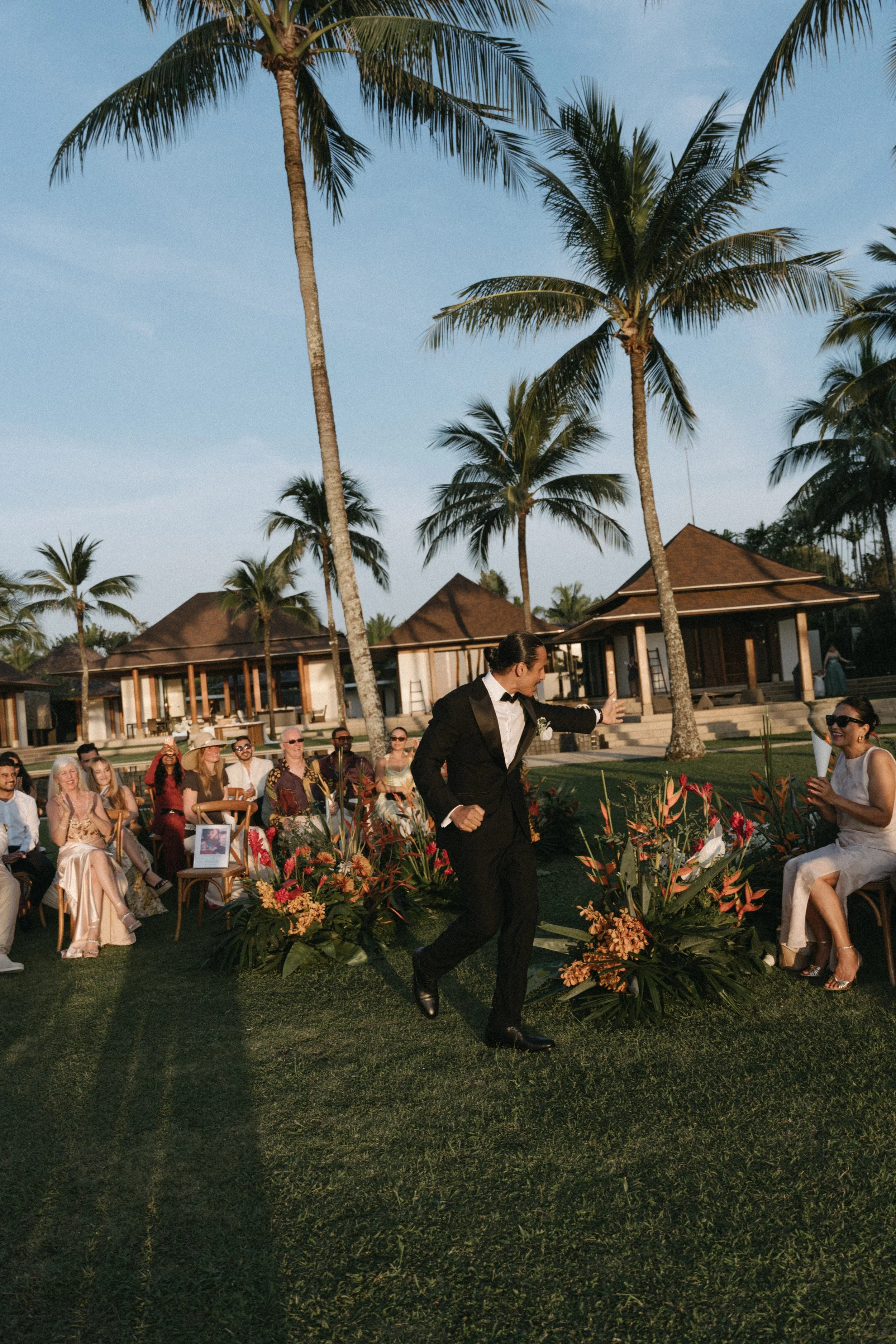 candid shot of groom high fiving happy guests as he arrives for wedding ceremony at villa shanti