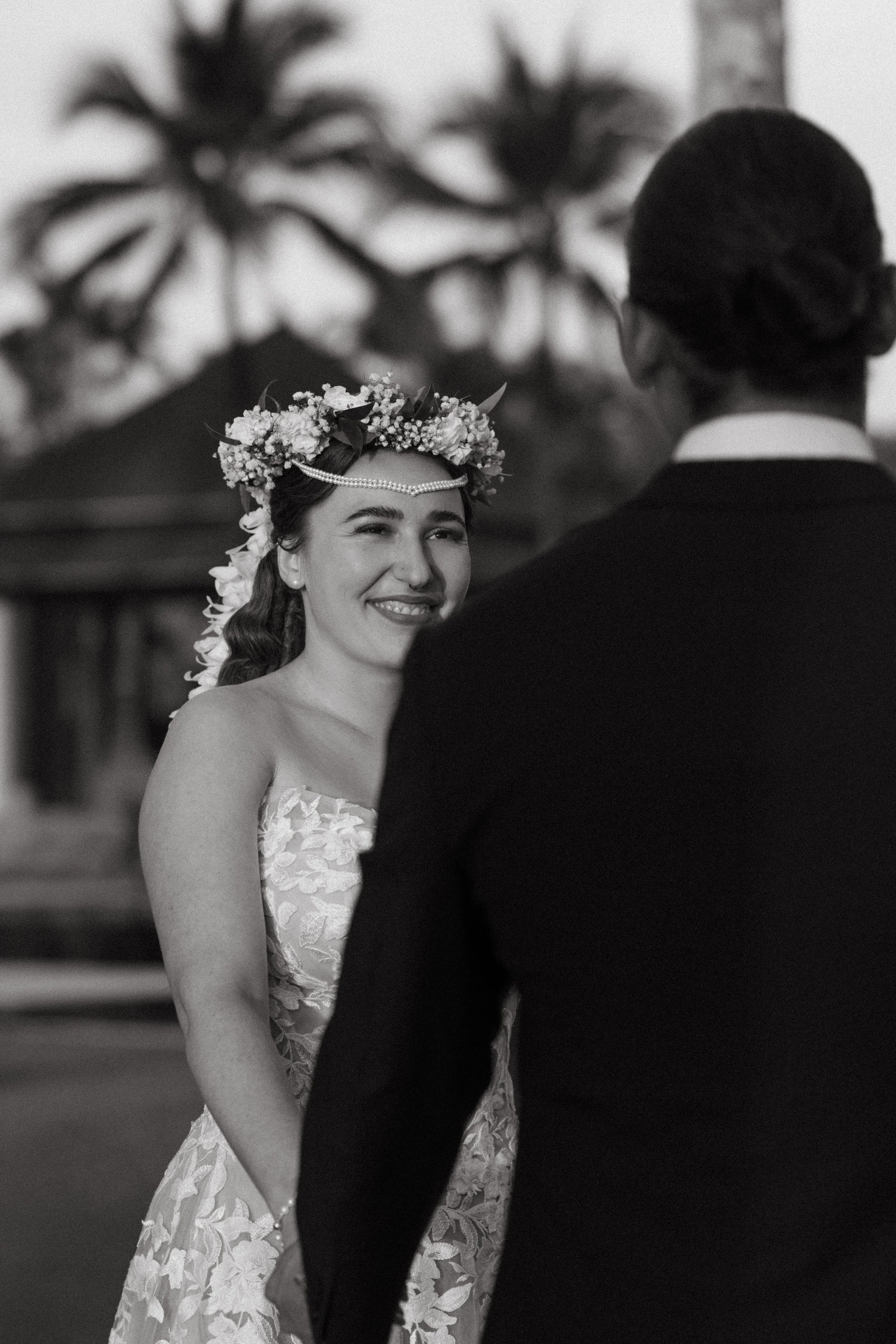 bride smiling and looking into groom's eyes during intimate outdoor wedding ceremony