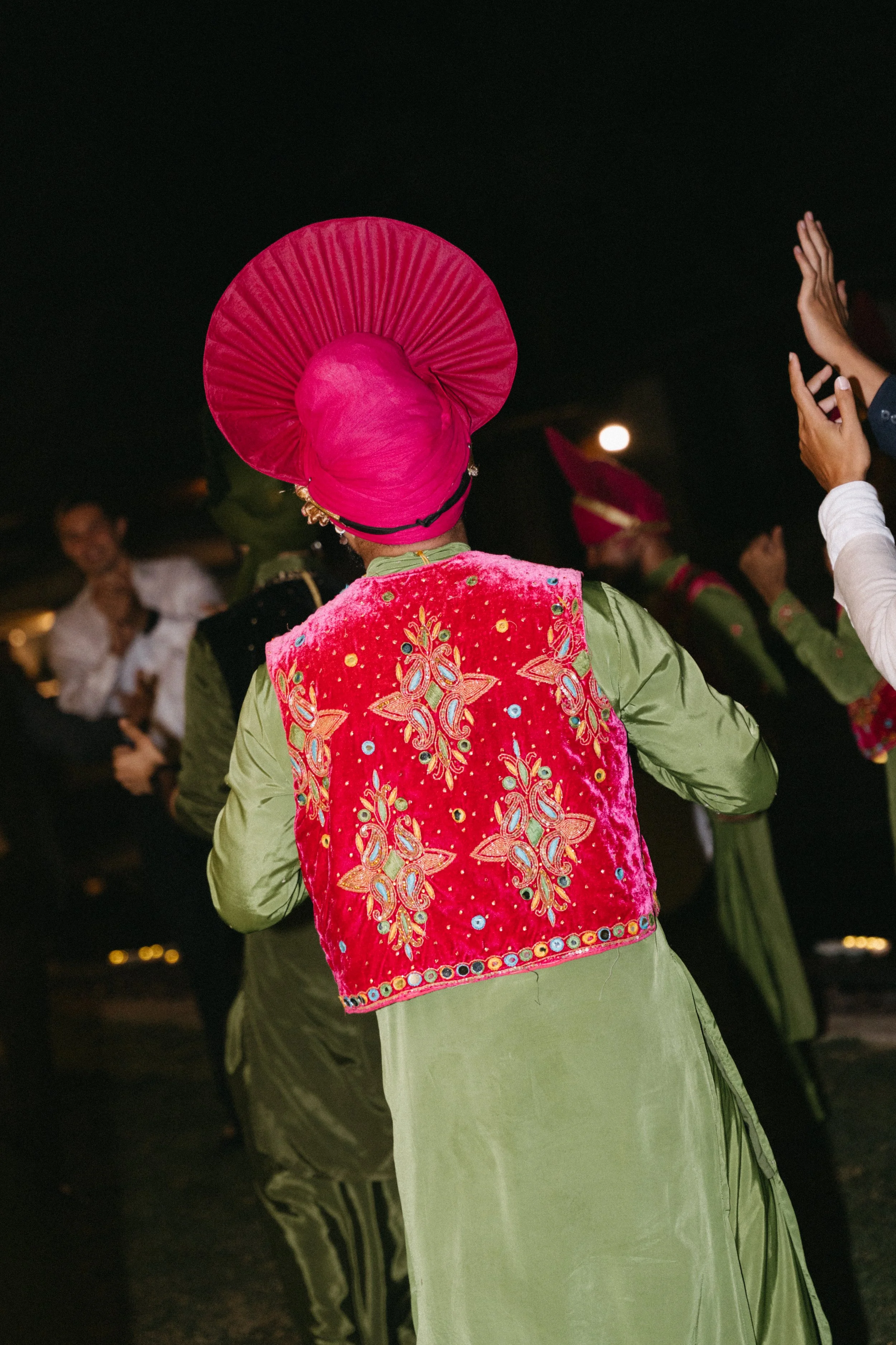 close up of traditional dancing performer's green and red outfit 