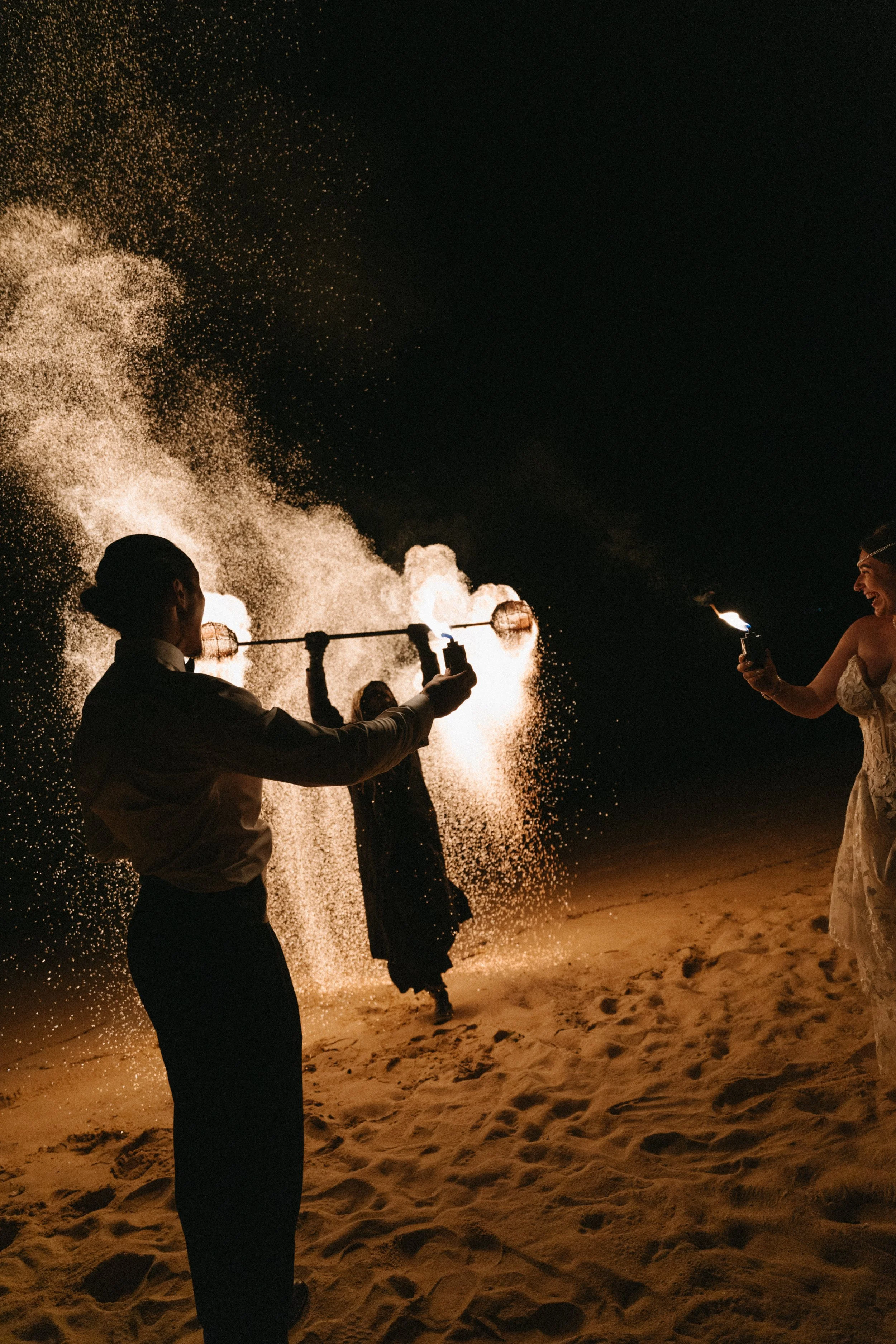 bride and groom watching gollita fire-spinning show after dessert