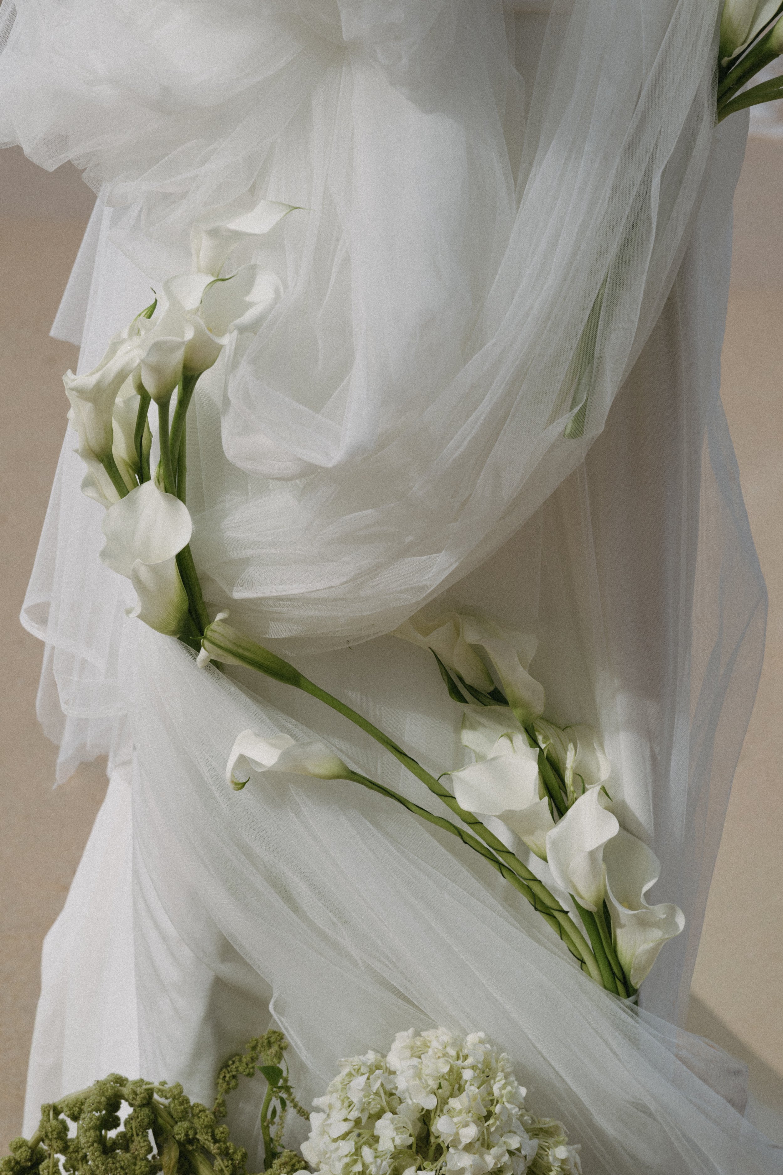 Modern wedding ceremony styling featuring white calla lilies and draped fabric at Odyssey Mansion in Koh Samui