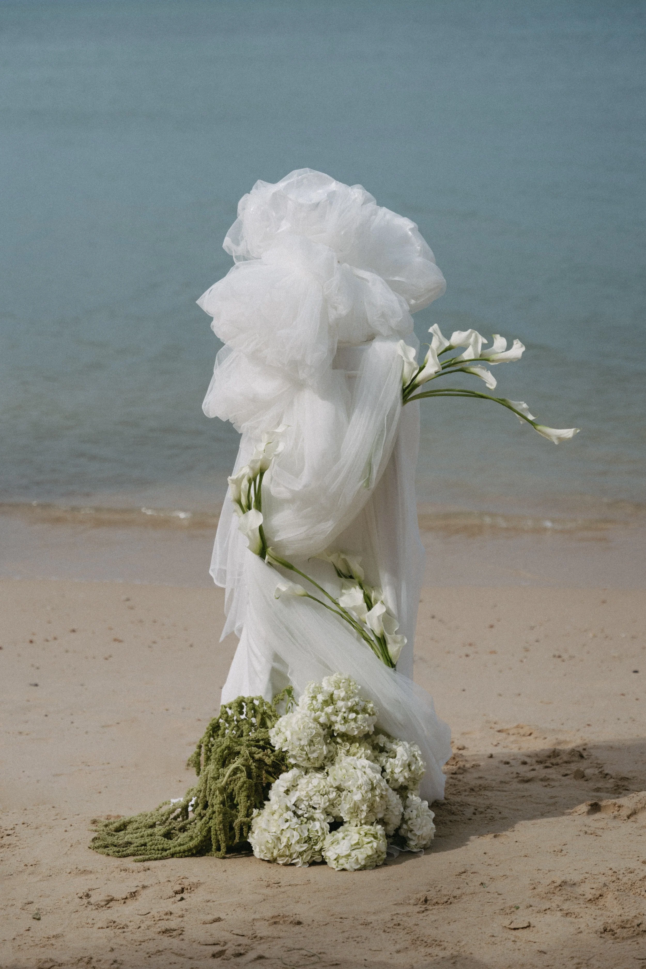 Ceremony aisle floral installation with flowing white fabric on the sand at a destination wedding on Bangrak Beach, Koh Samui