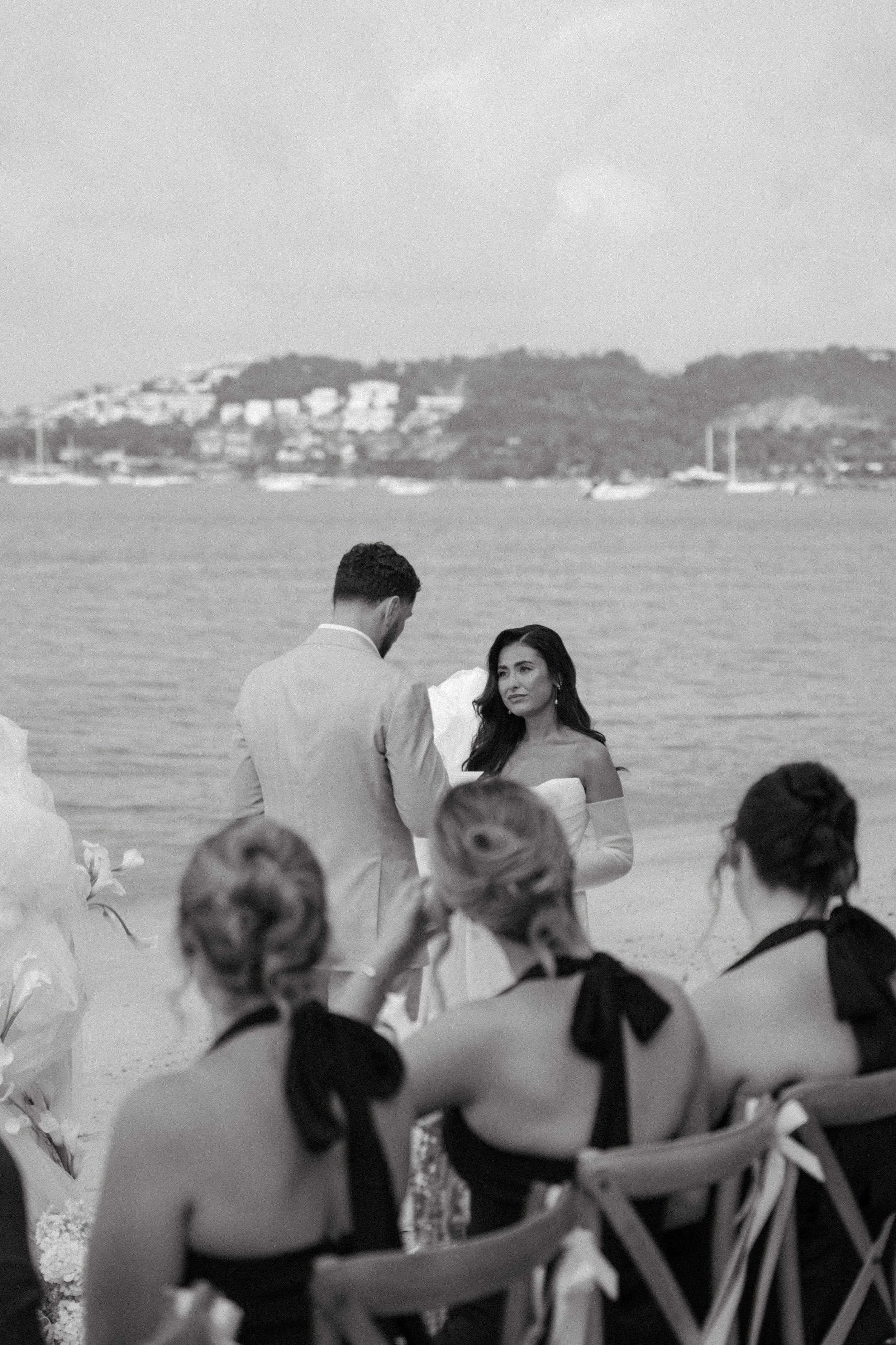 elegant black and white portrait of groom reading his vows during ceremony on bangrak beach