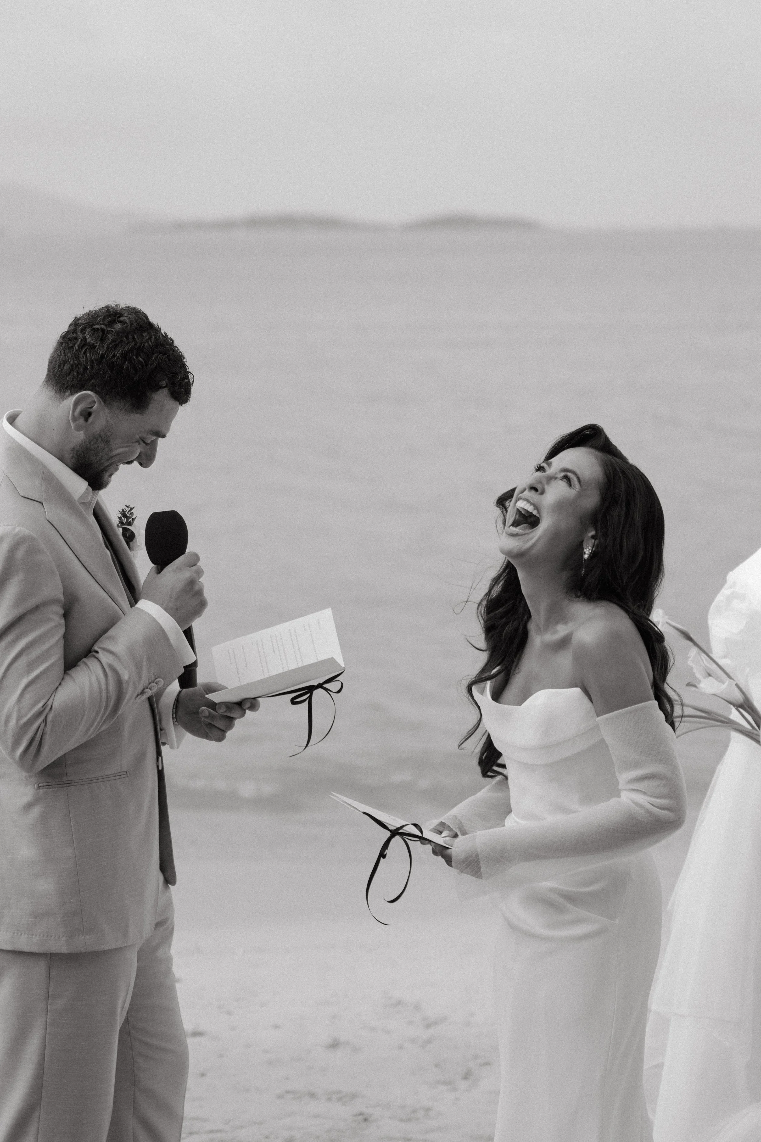 bride laughing as groom reads his vows during wedding ceremony on bangrak beach