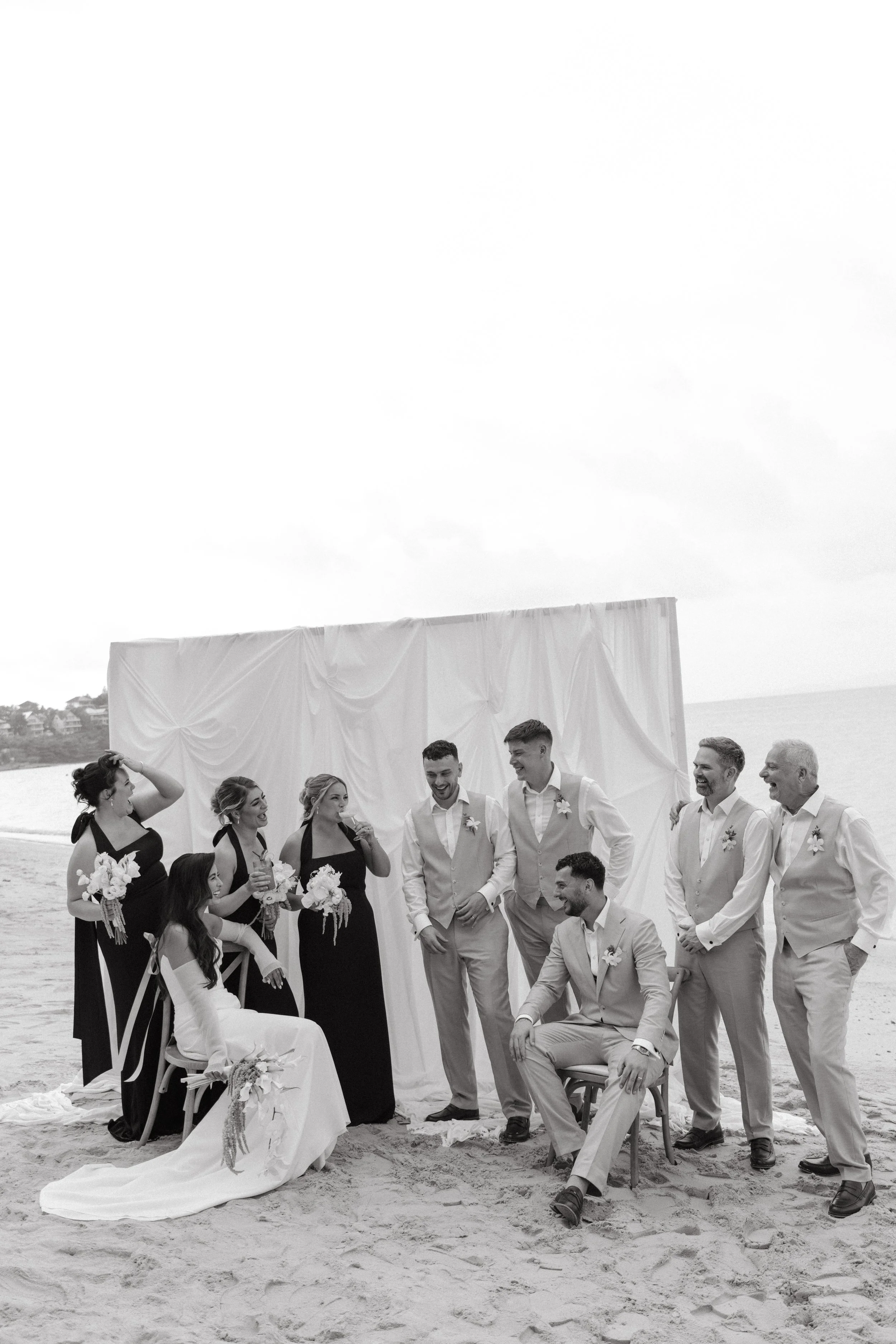 candid shot of bride and groom with their entire wedding party after bangrak beach ceremony