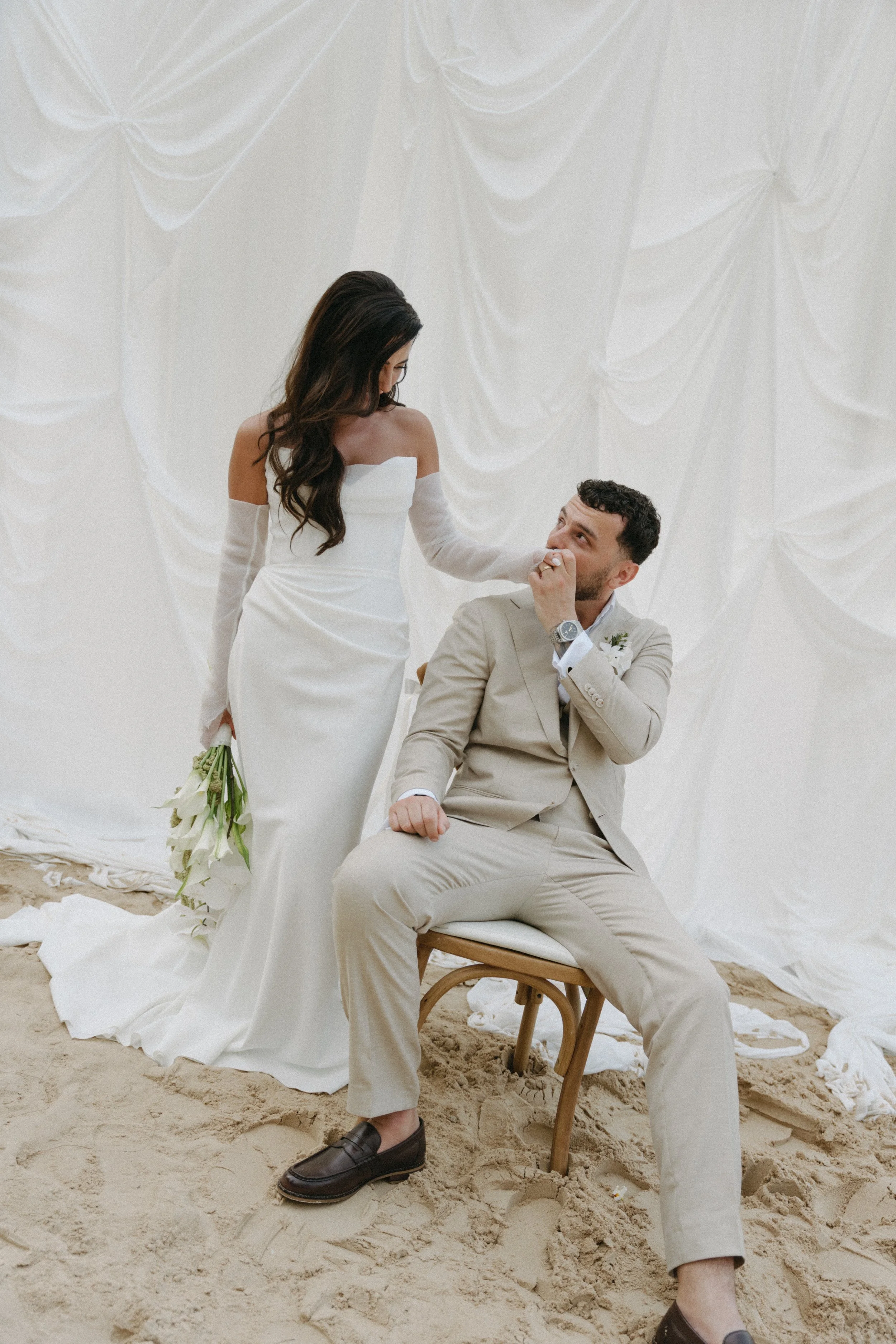 elegant portrait of bride and groom in front of draped photo backdrop on bangrak beach