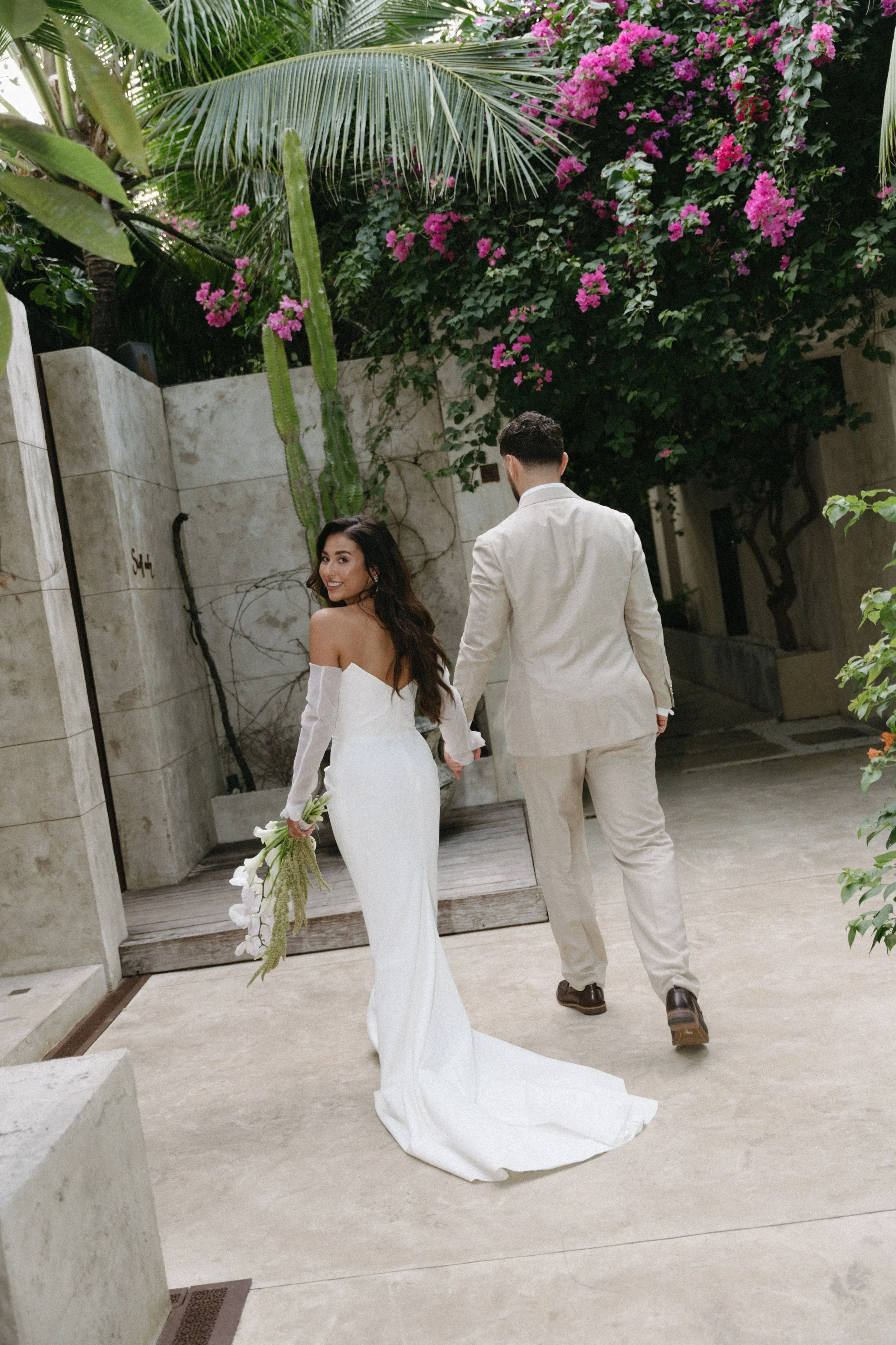 bride looking back as she walks away with the groom at odyssey mansion