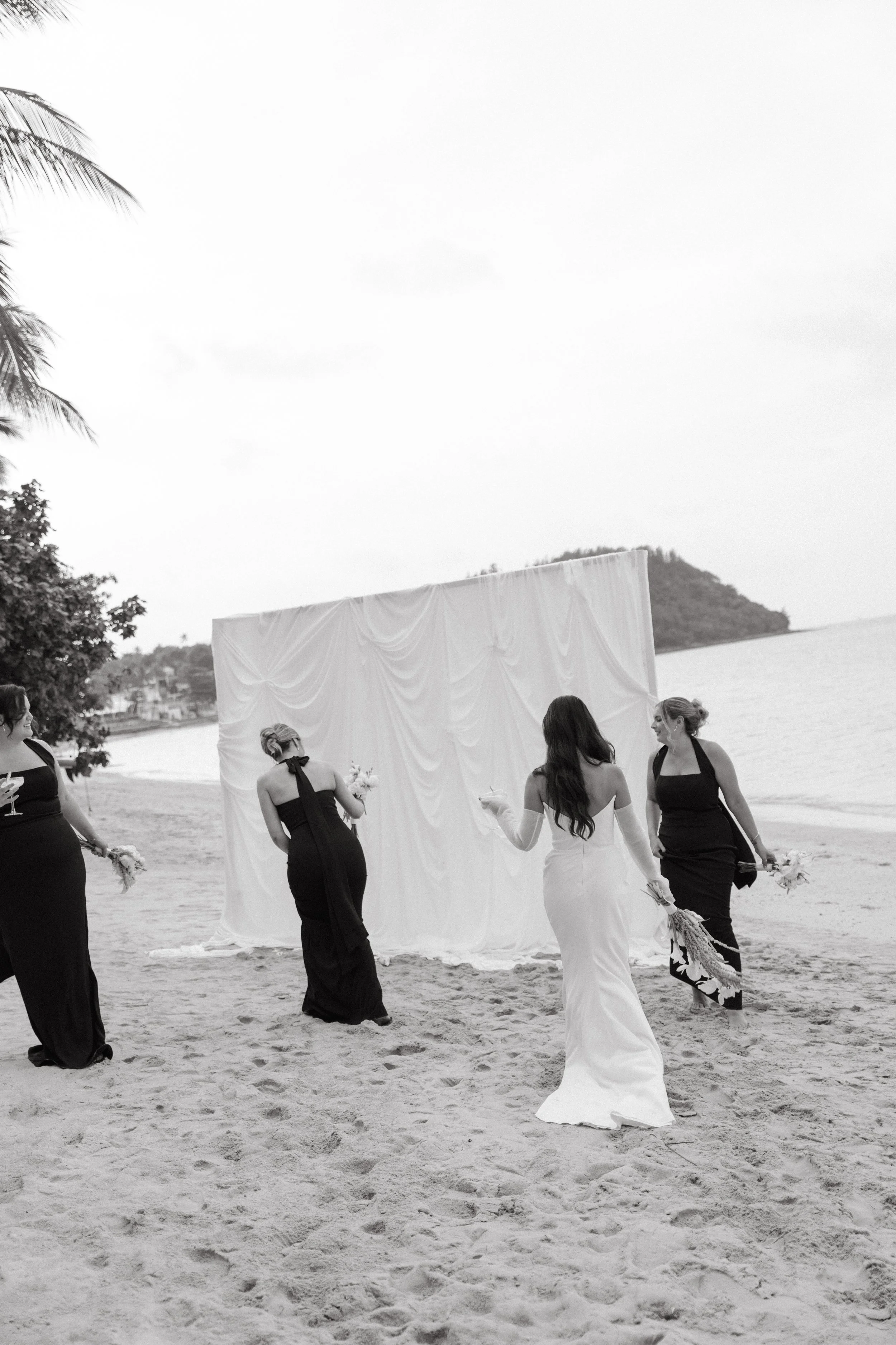 candid portrait of bride with bridal party on the beach after wedding ceremony