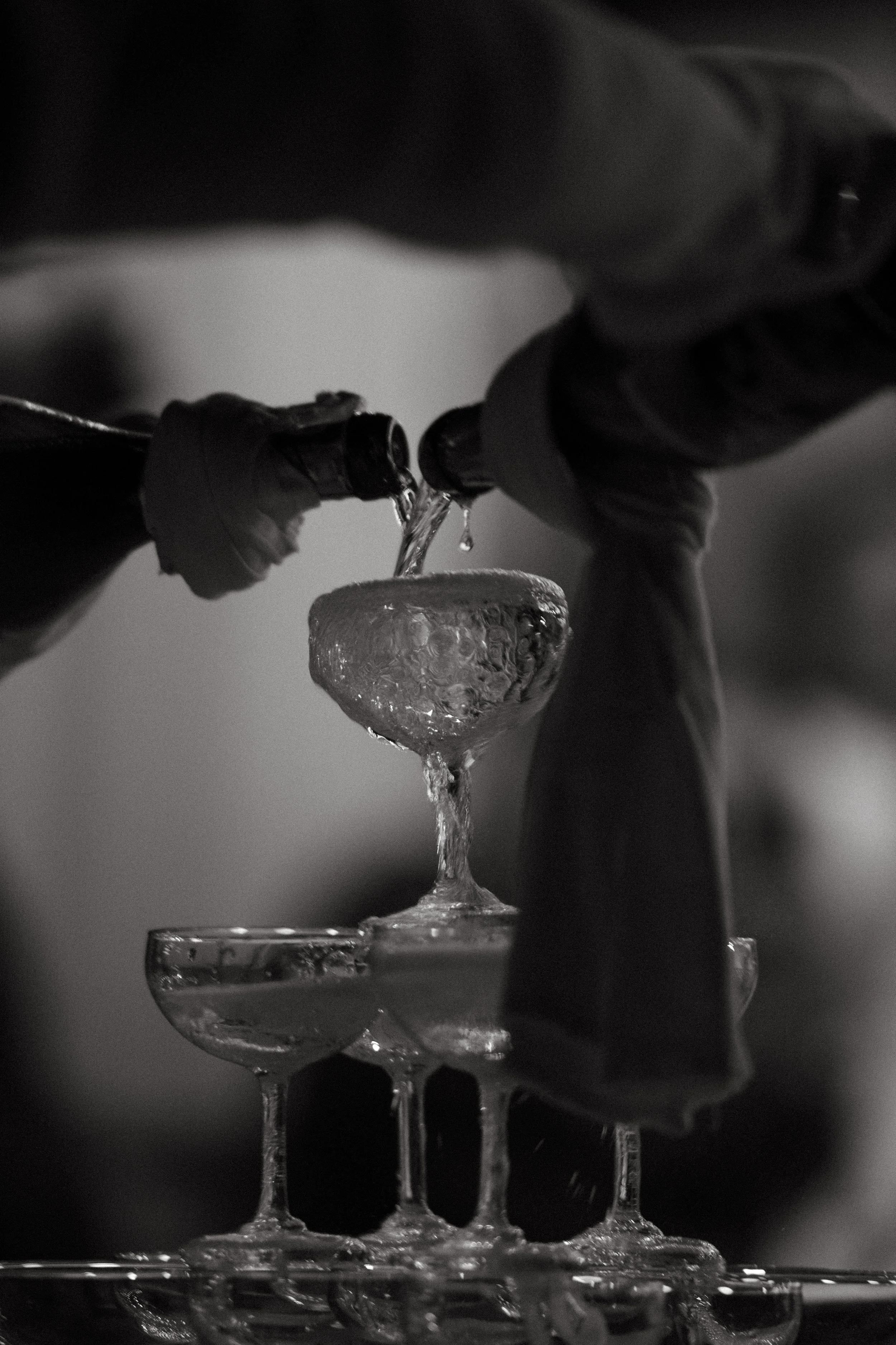 Champagne glasses being poured during a destination wedding reception at Odyssey Mansion, Koh Samui