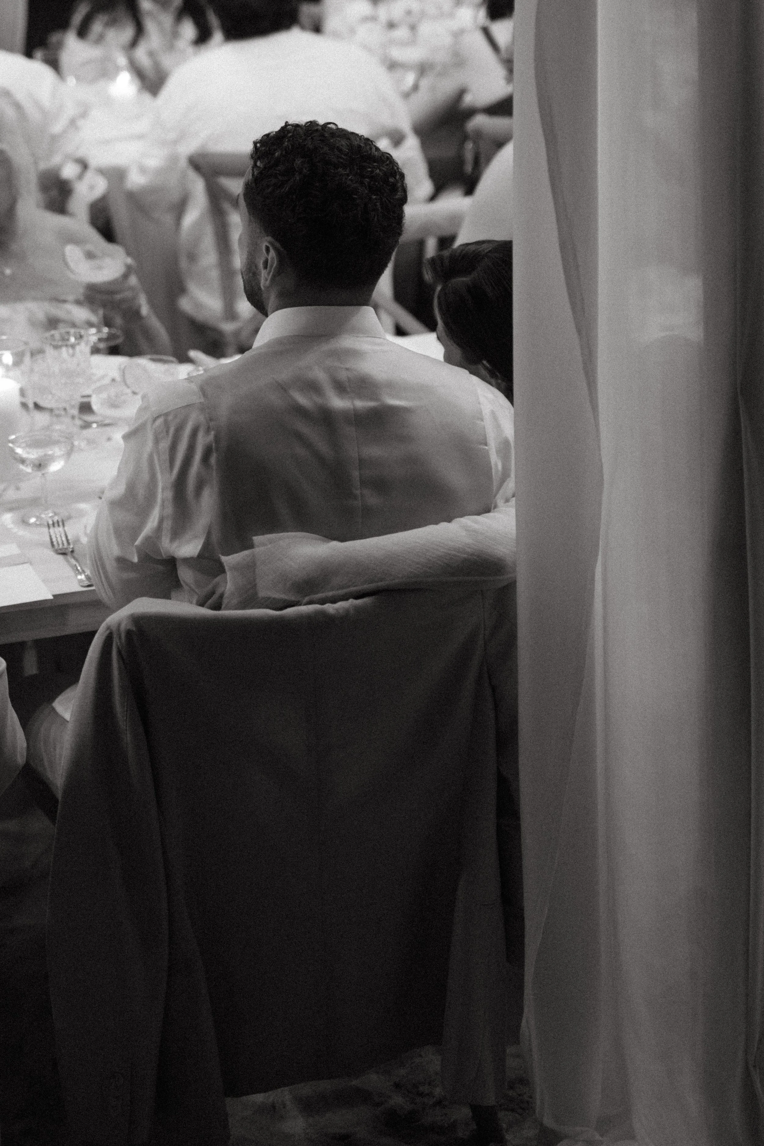 Candid black and white photo of guests celebrating at a destination wedding reception at Odyssey Mansion, Koh Samui