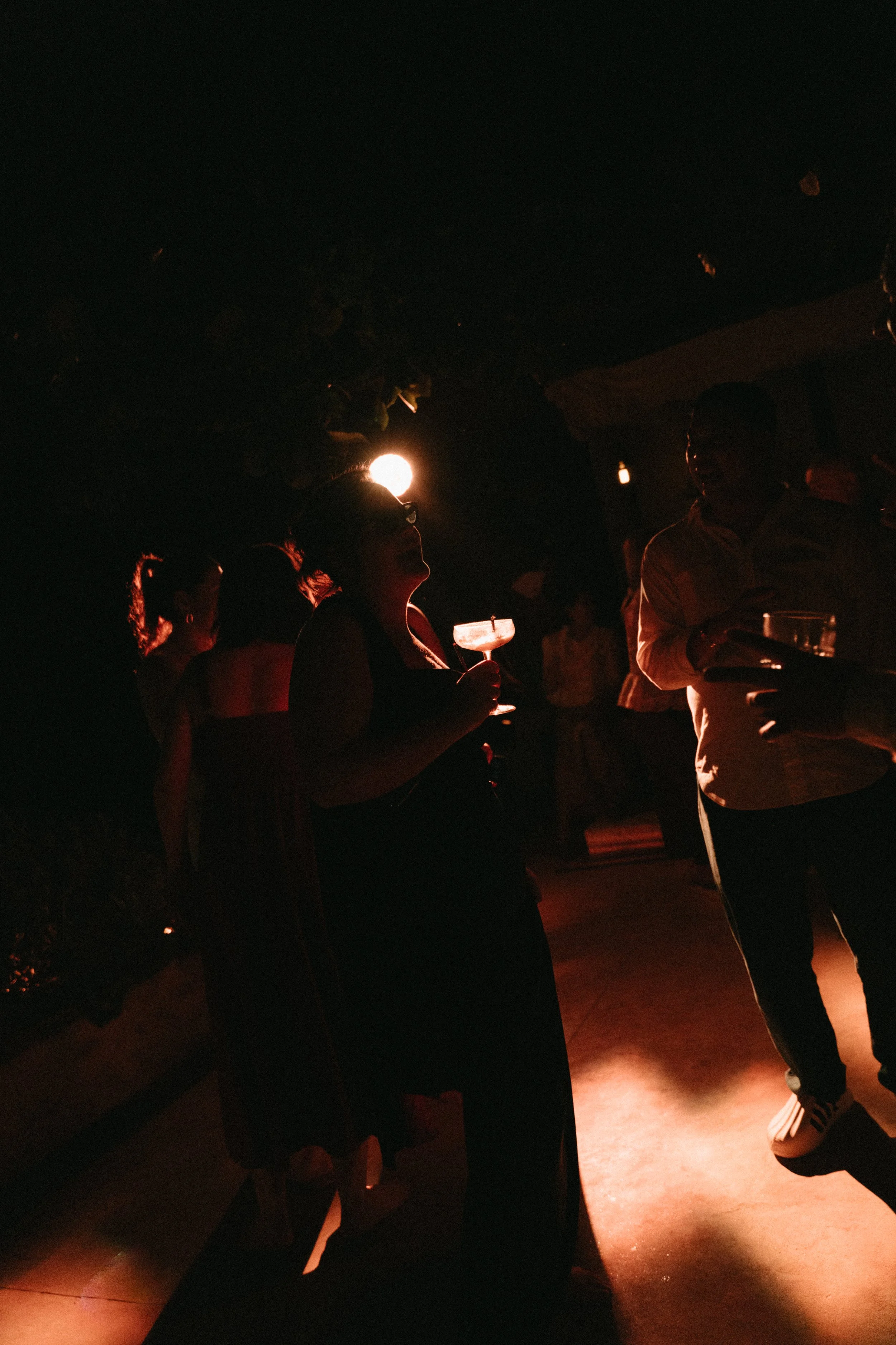Guests dancing under warm evening lighting at an outdoor wedding reception at Odyssey Mansion, Koh Samui
