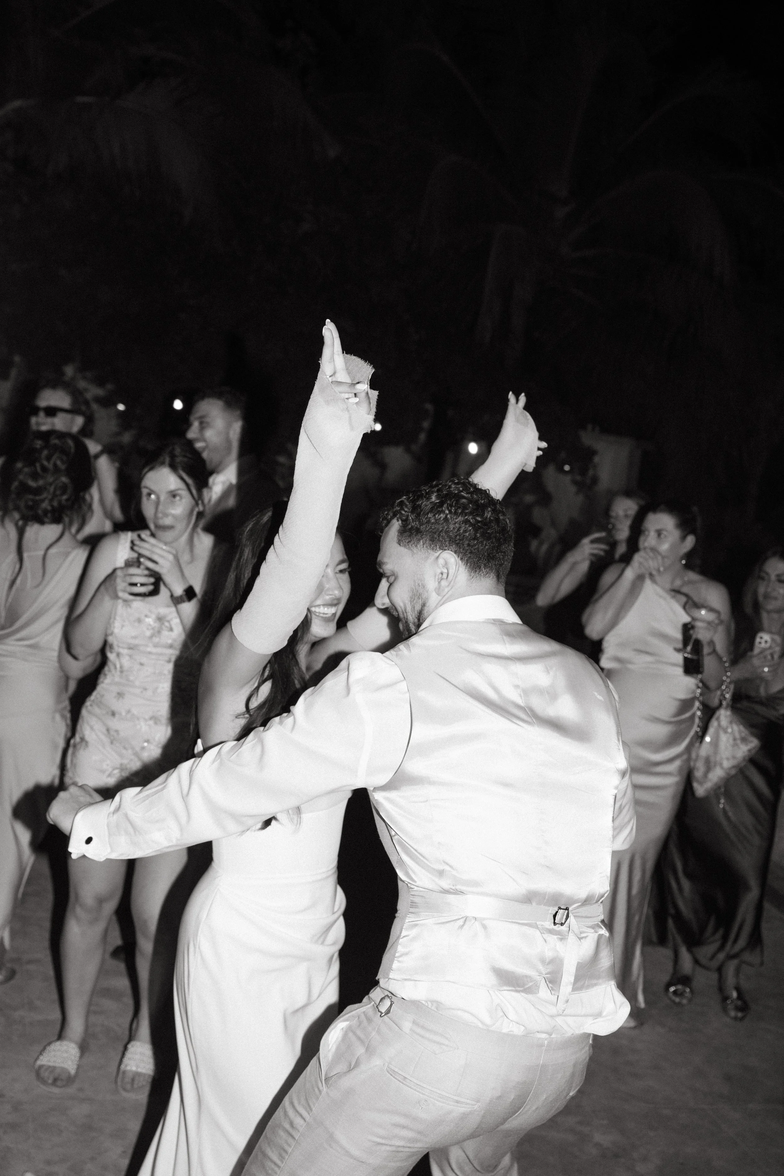 bride and groom dancing and celebrating on the sand at a night reception on Bangrak Beach, Koh Samui