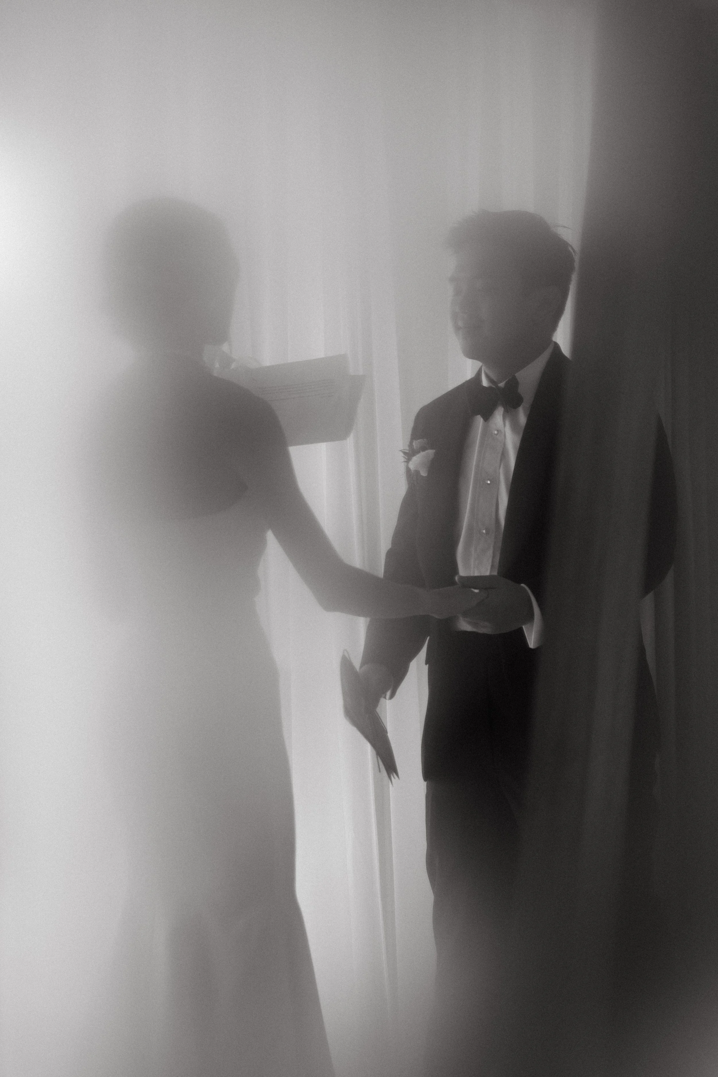 Silhouette of bride and groom holding hands behind sheer curtain, moody editorial wedding portrait at COMO Point Yamu