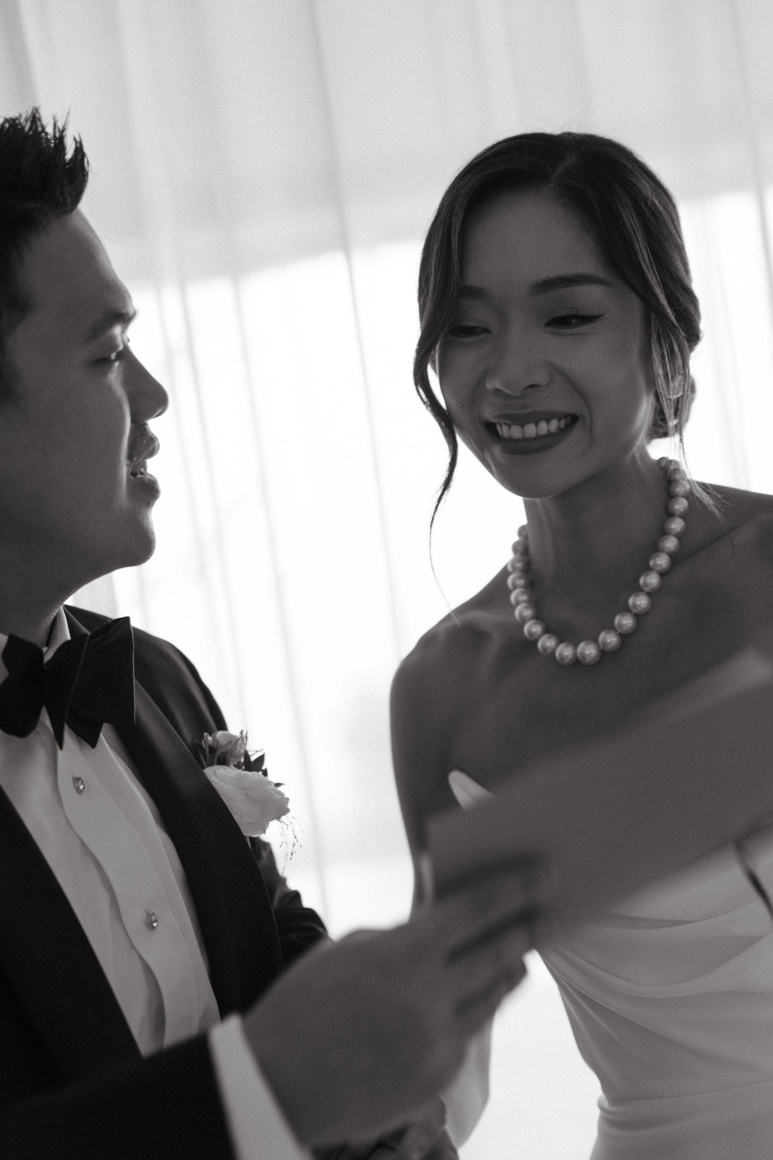 Bride and groom smiling intimately face to face after private vows, candid black and white wedding photo