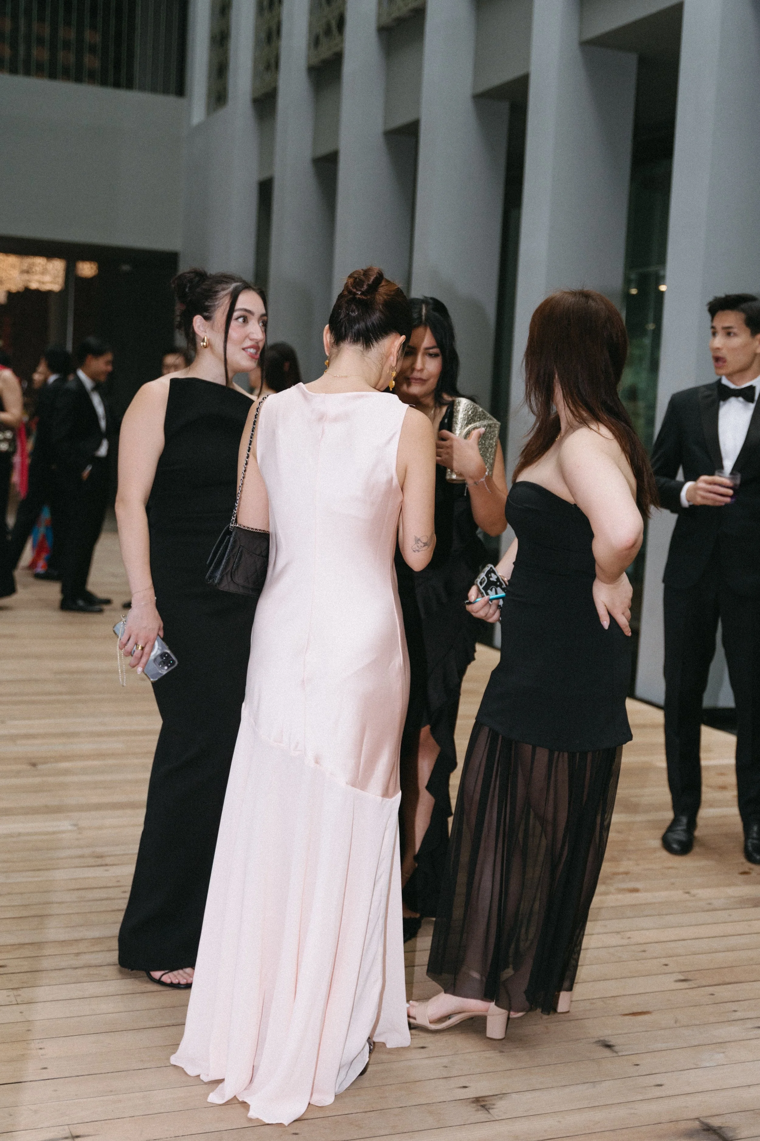 Guests in black and blush gowns mingling before Phuket wedding ceremony