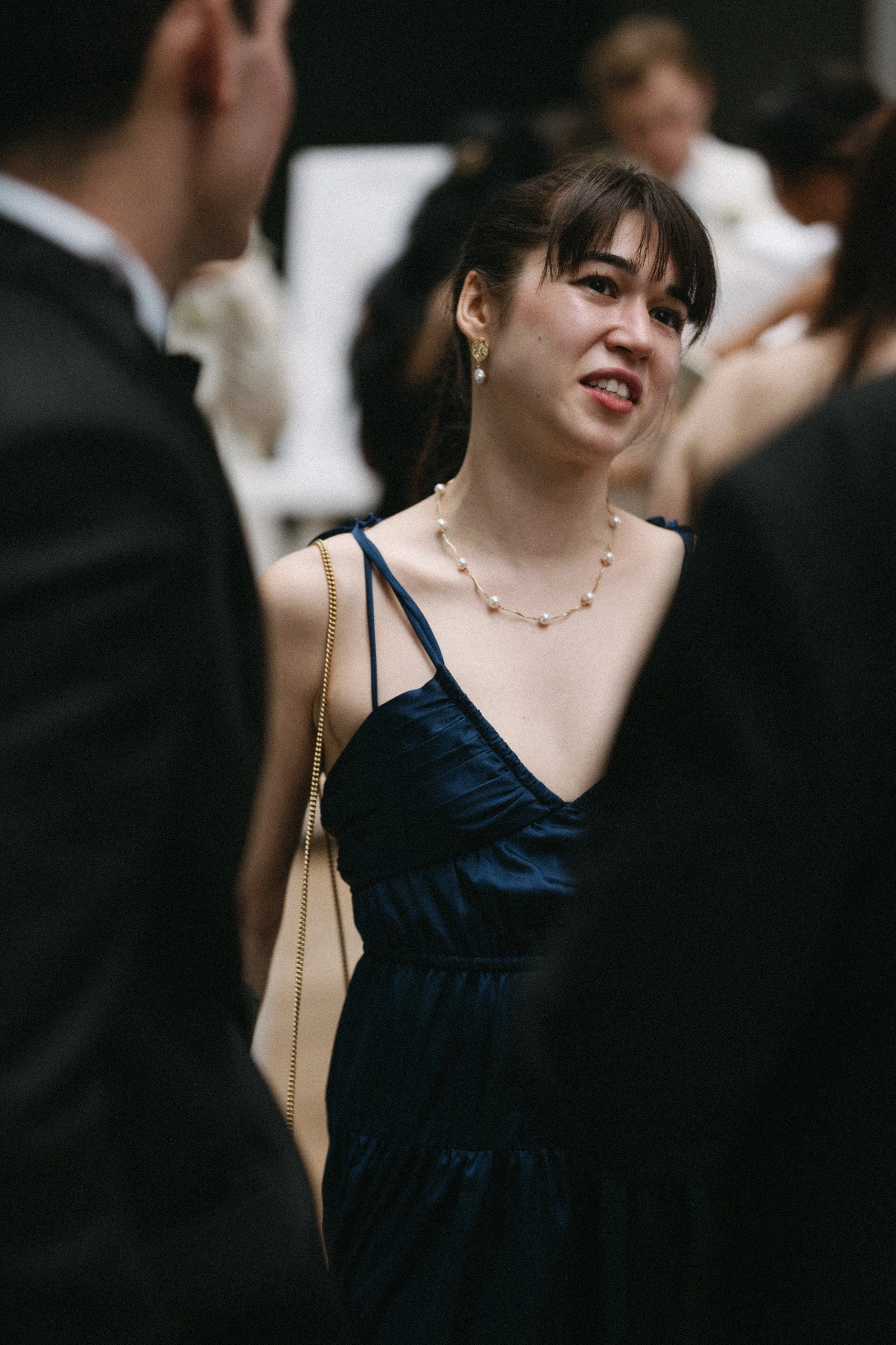 Female guest in navy slip dress chatting during pre-ceremony welcome drinks