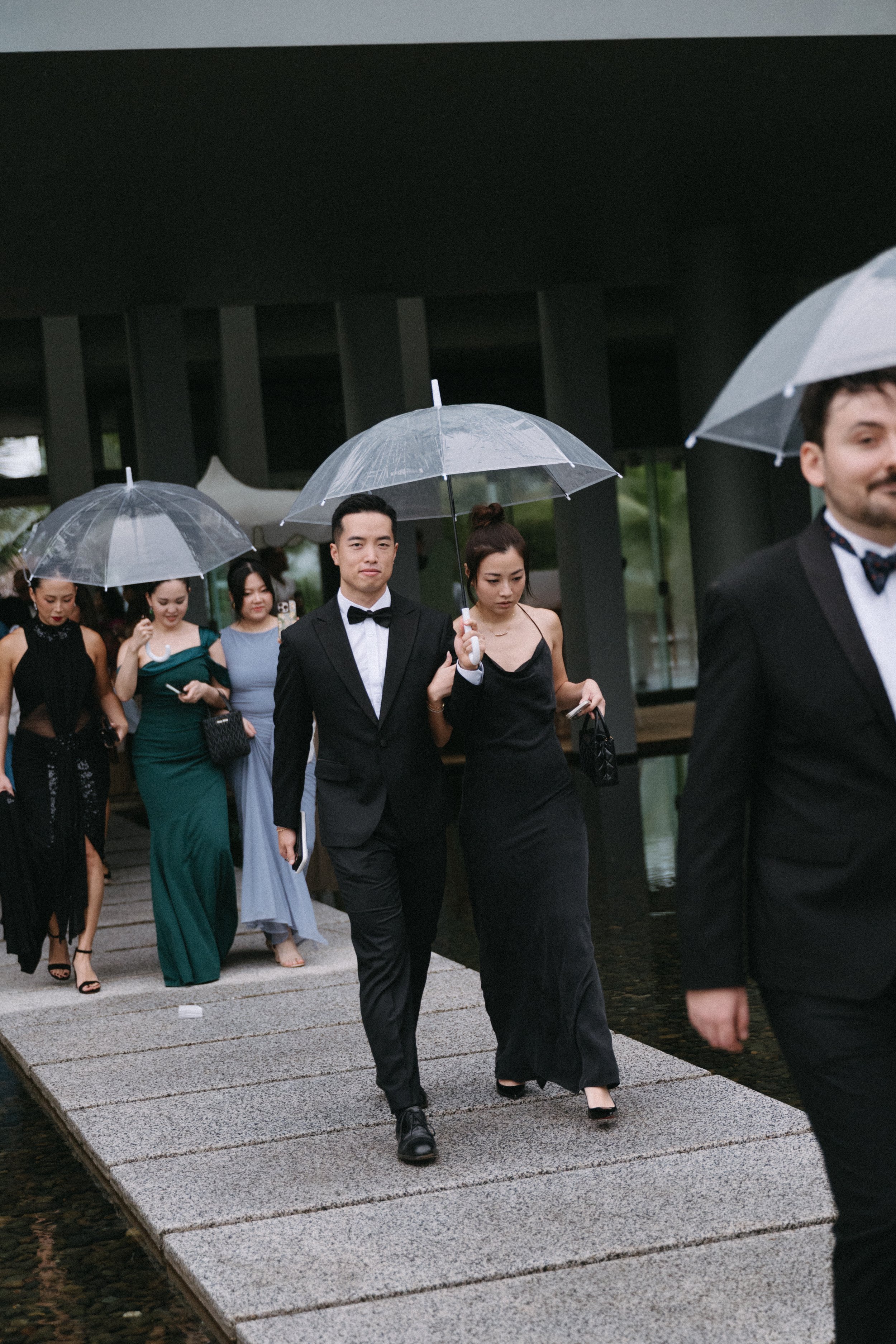 guests walking to rainy ceremony under clear umbrellas at COMO Point Yamu