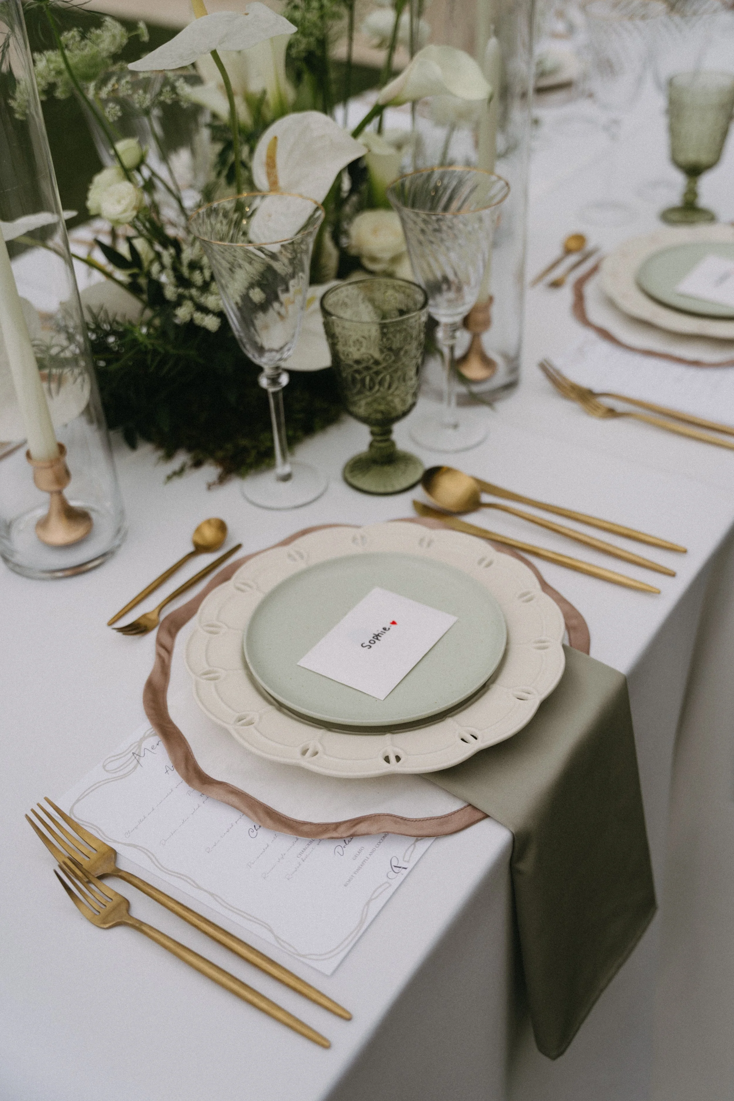 Green glassware and gold cutlery place setting, lawn reception styling at Phuket destination wedding