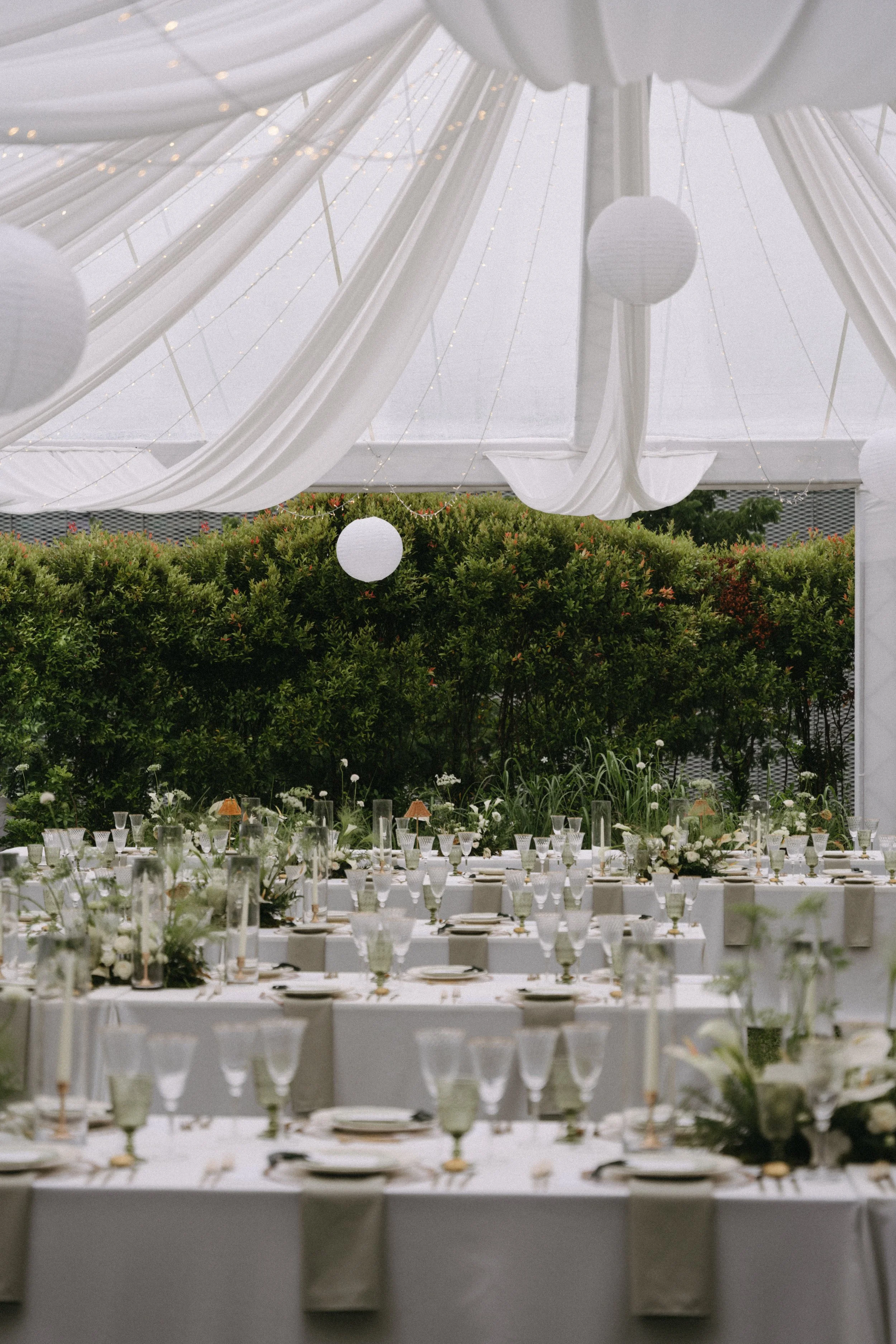 Long guest tables set up under marquee on the lawn at COMO Point Yamu