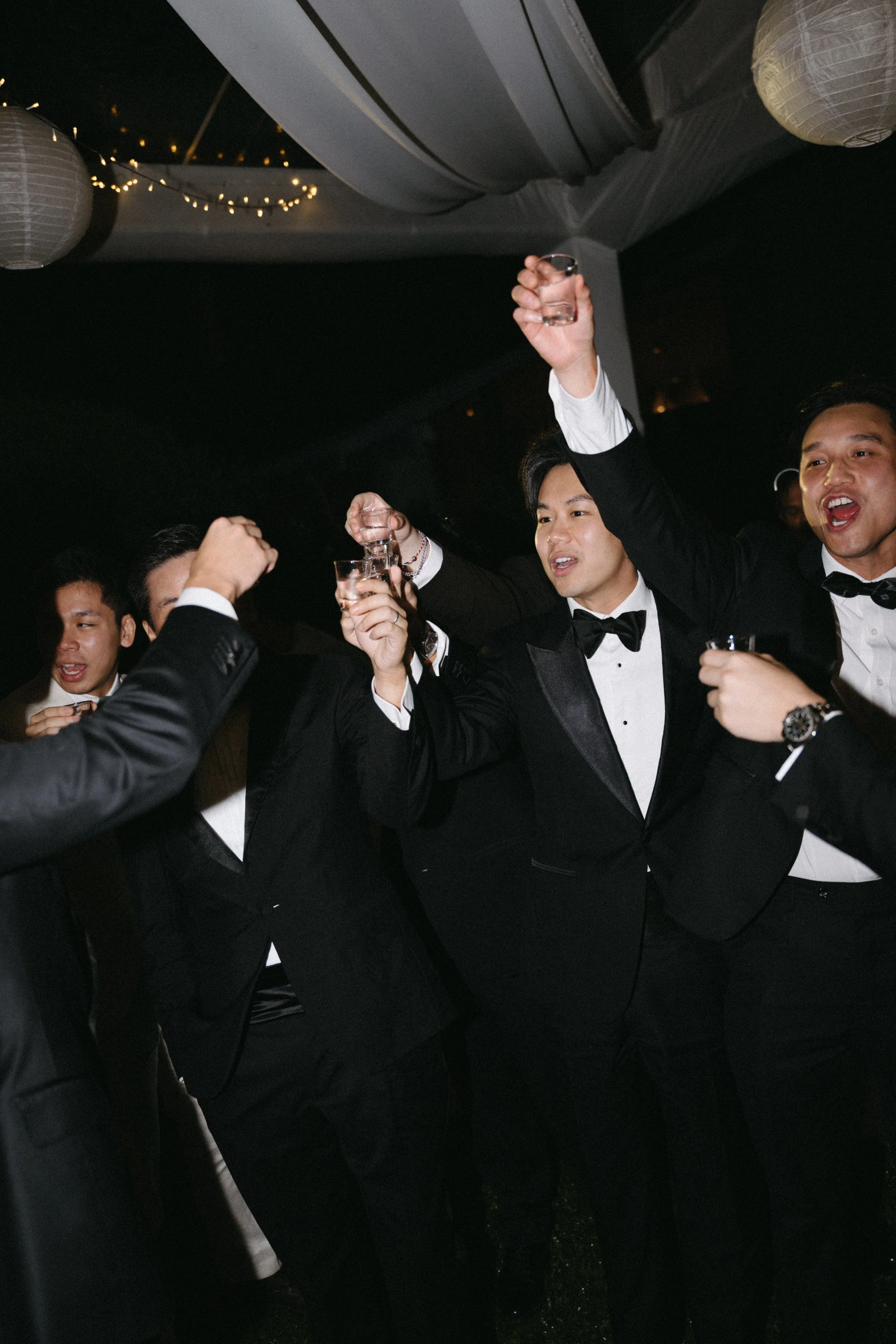 guests  in black tie singing and celebrating together at reception party