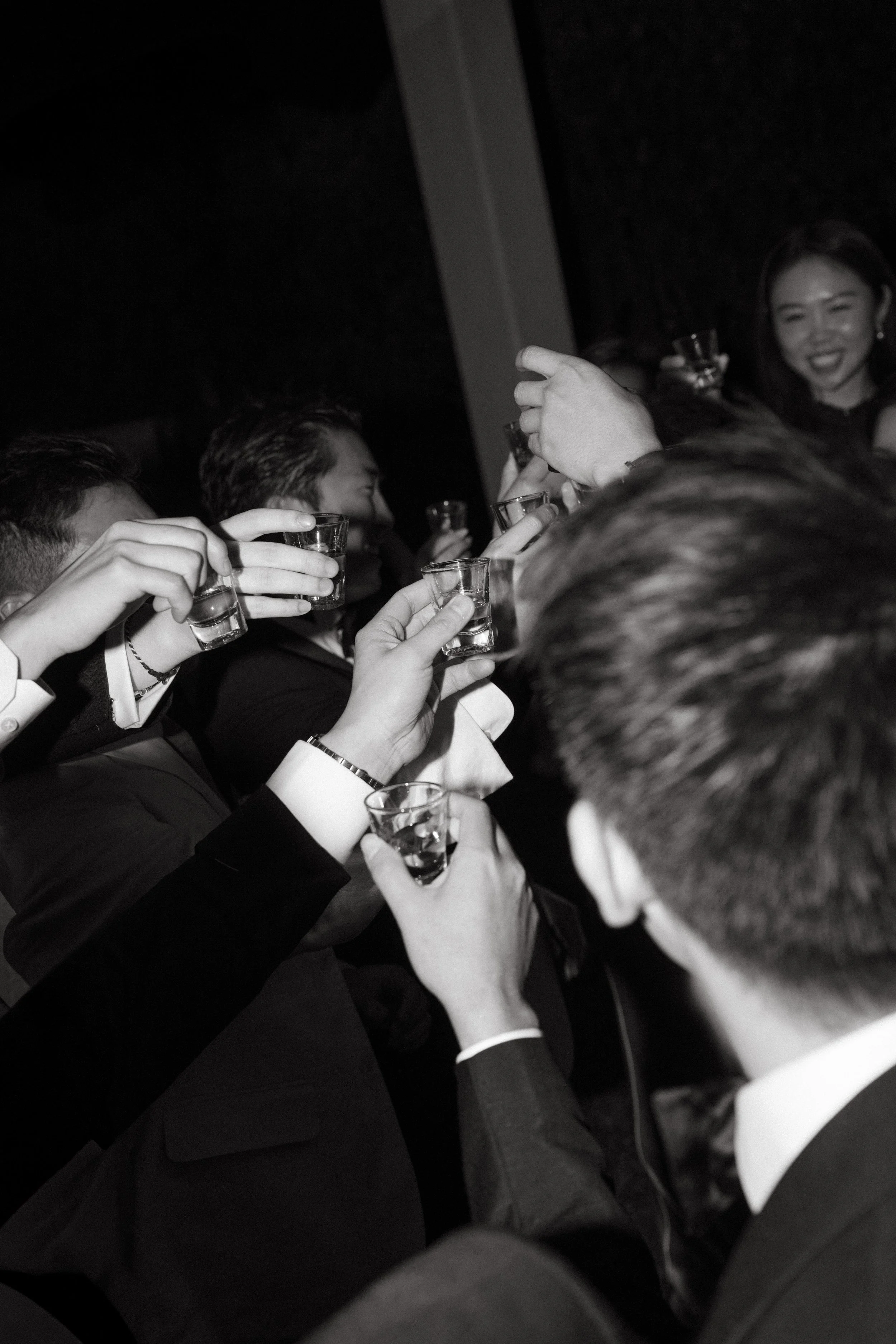 Guests raising glasses in celebratory toast at night reception