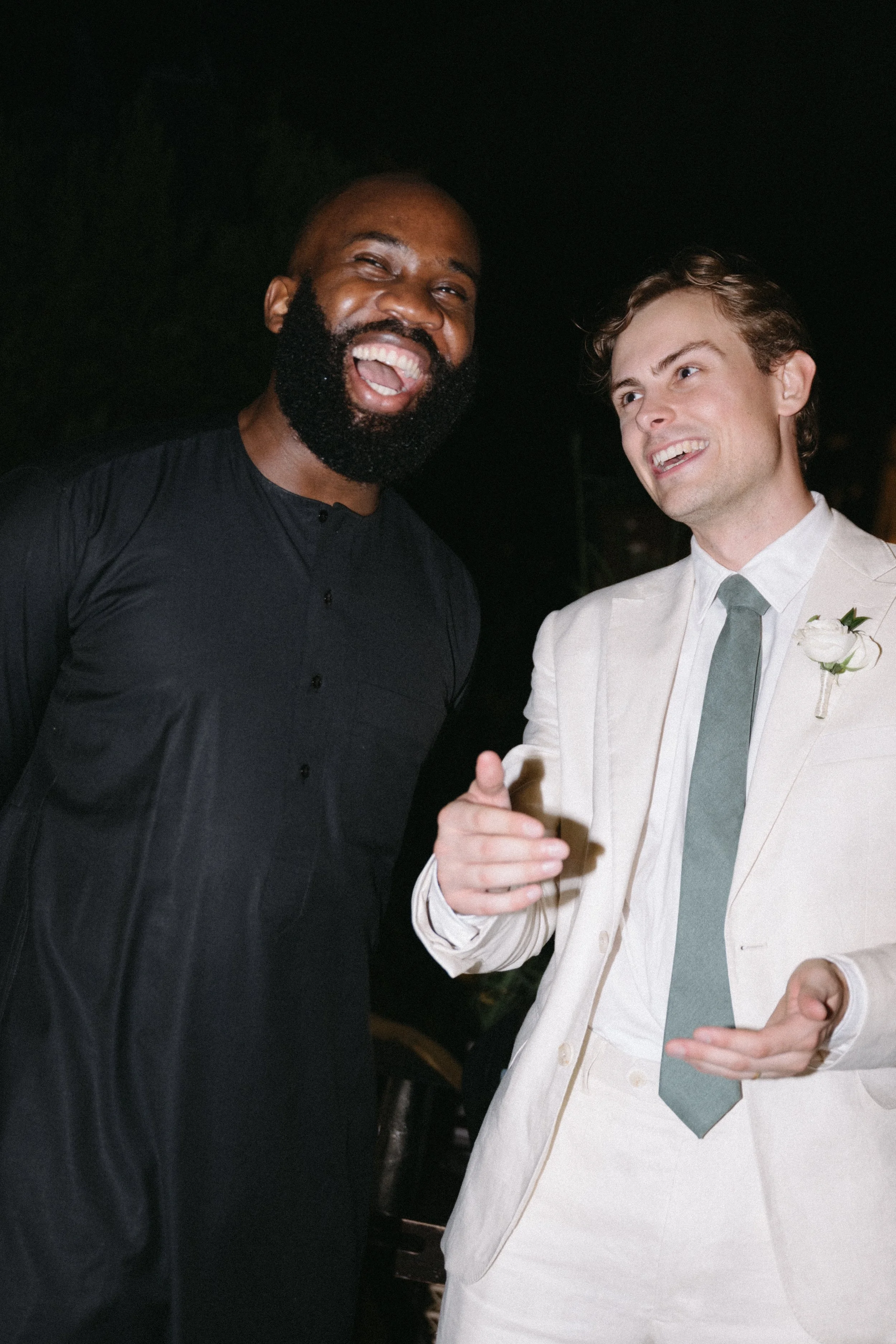 Male guest smiling while holding drink at wedding reception