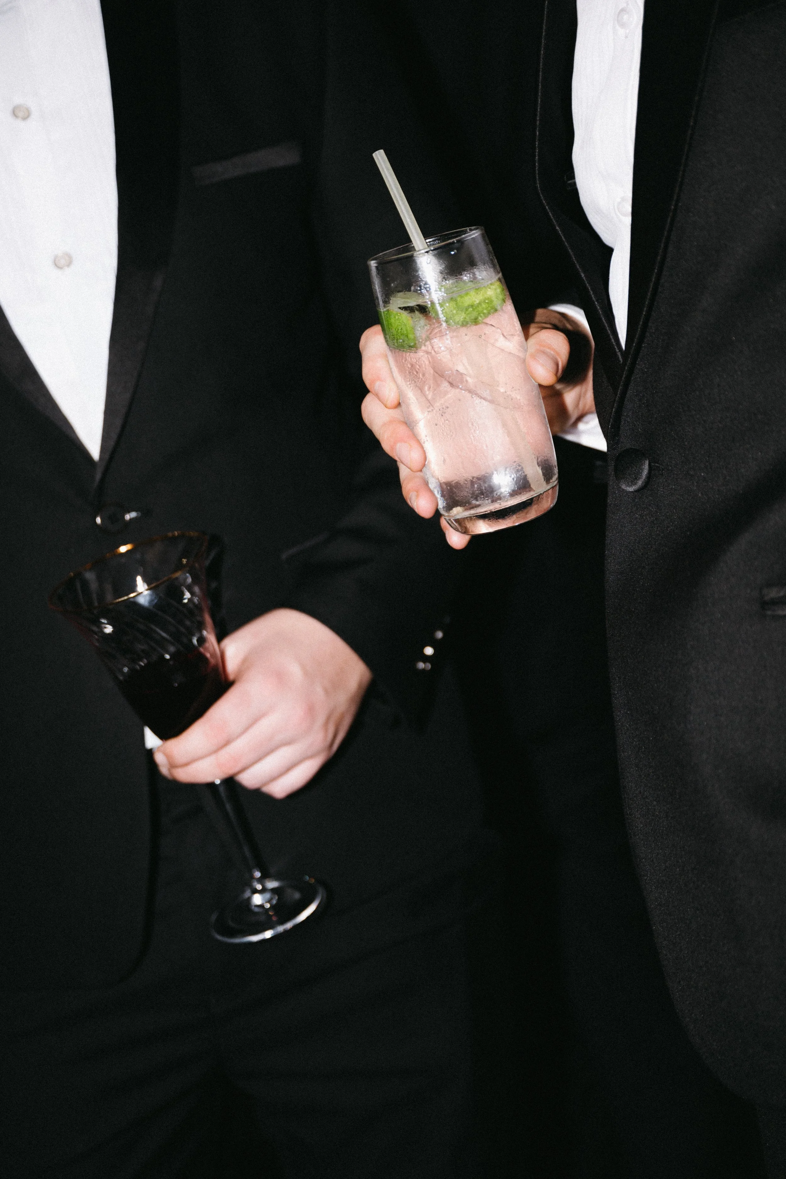 Close-up of guest's hand holding cocktail glass at evening reception