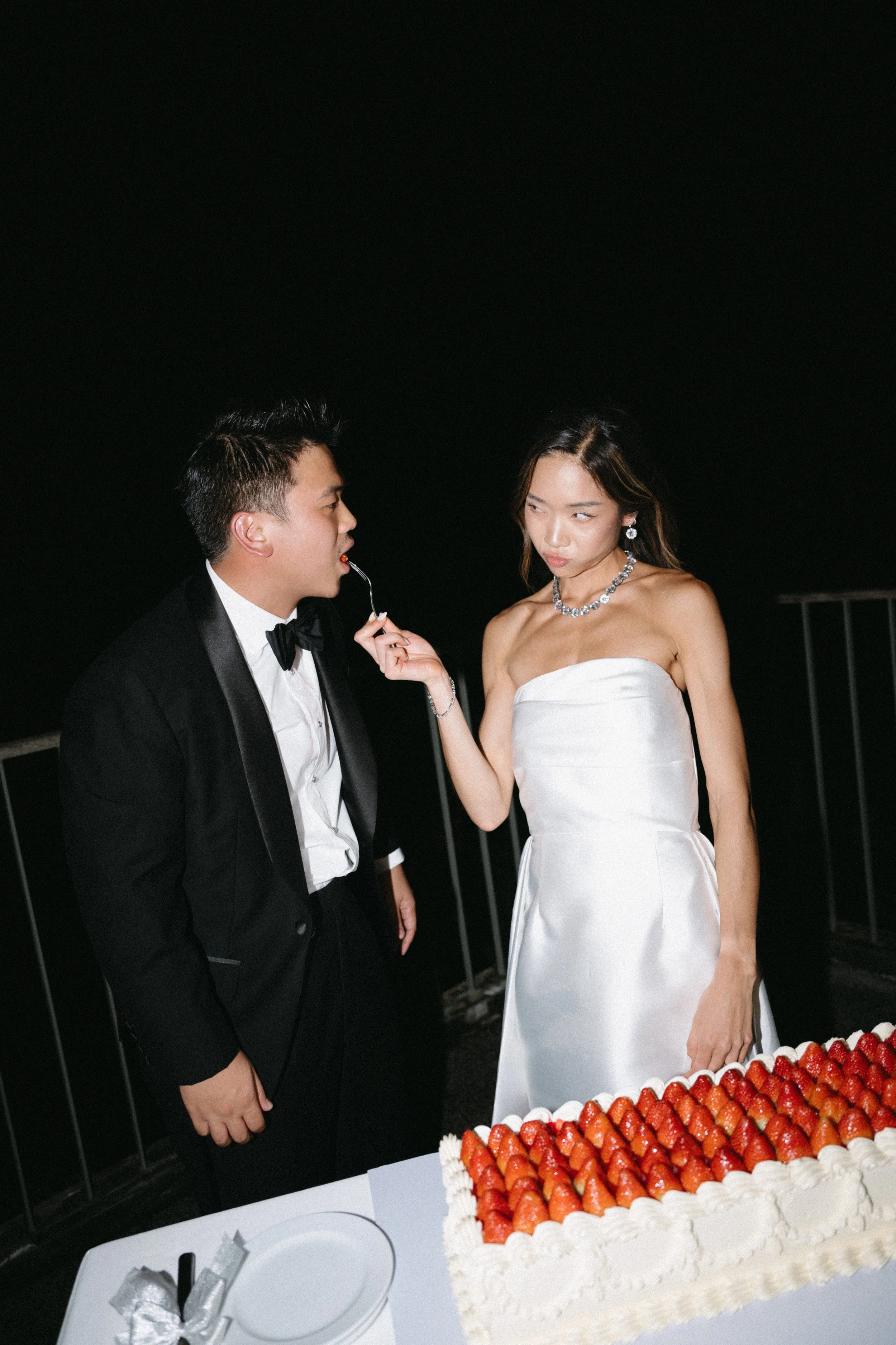 bride feeding groom  a bite of strawberry wedding cake at COMO Point Yamu reception
