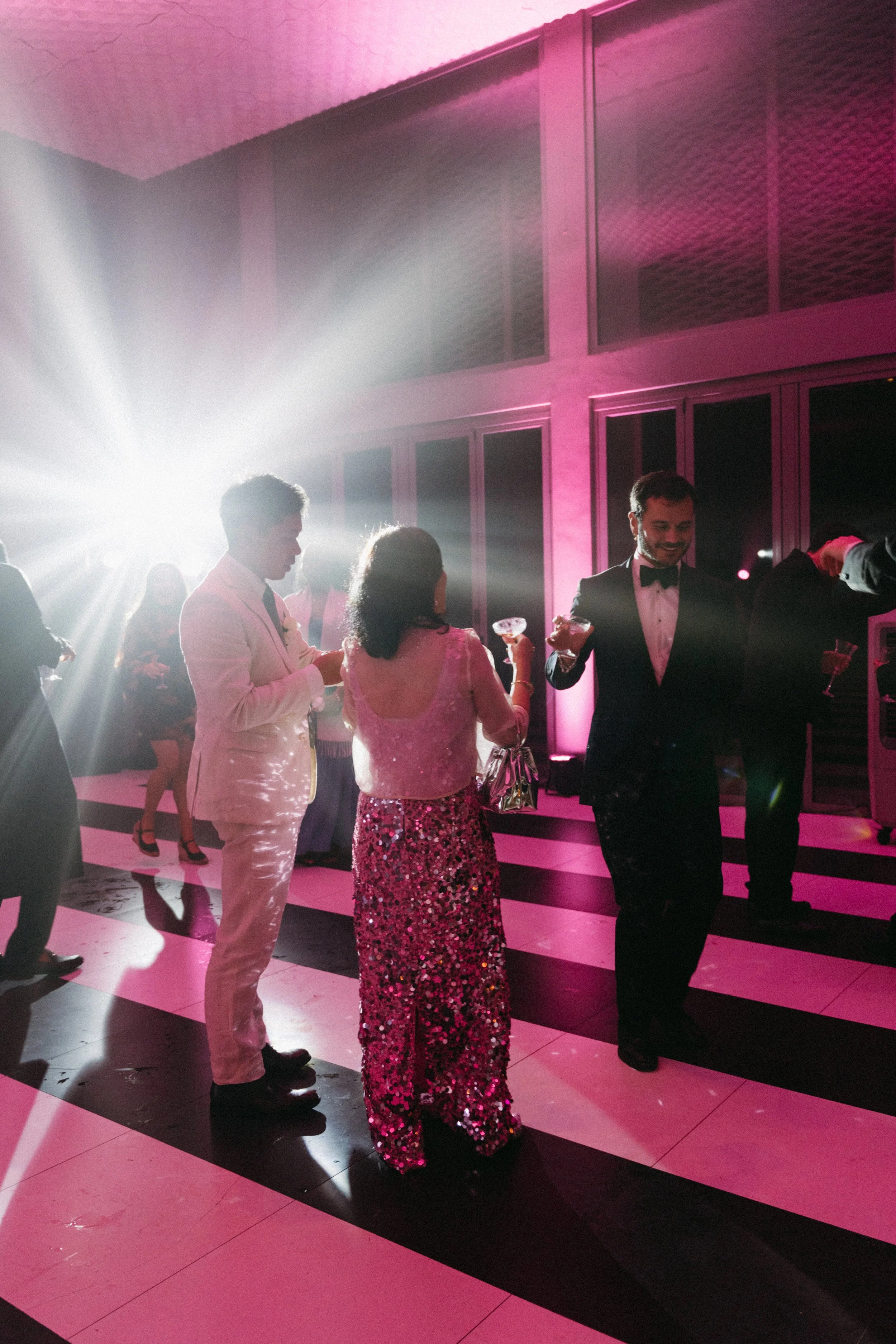 Guests in eveningwear dancing together on striped dance floor