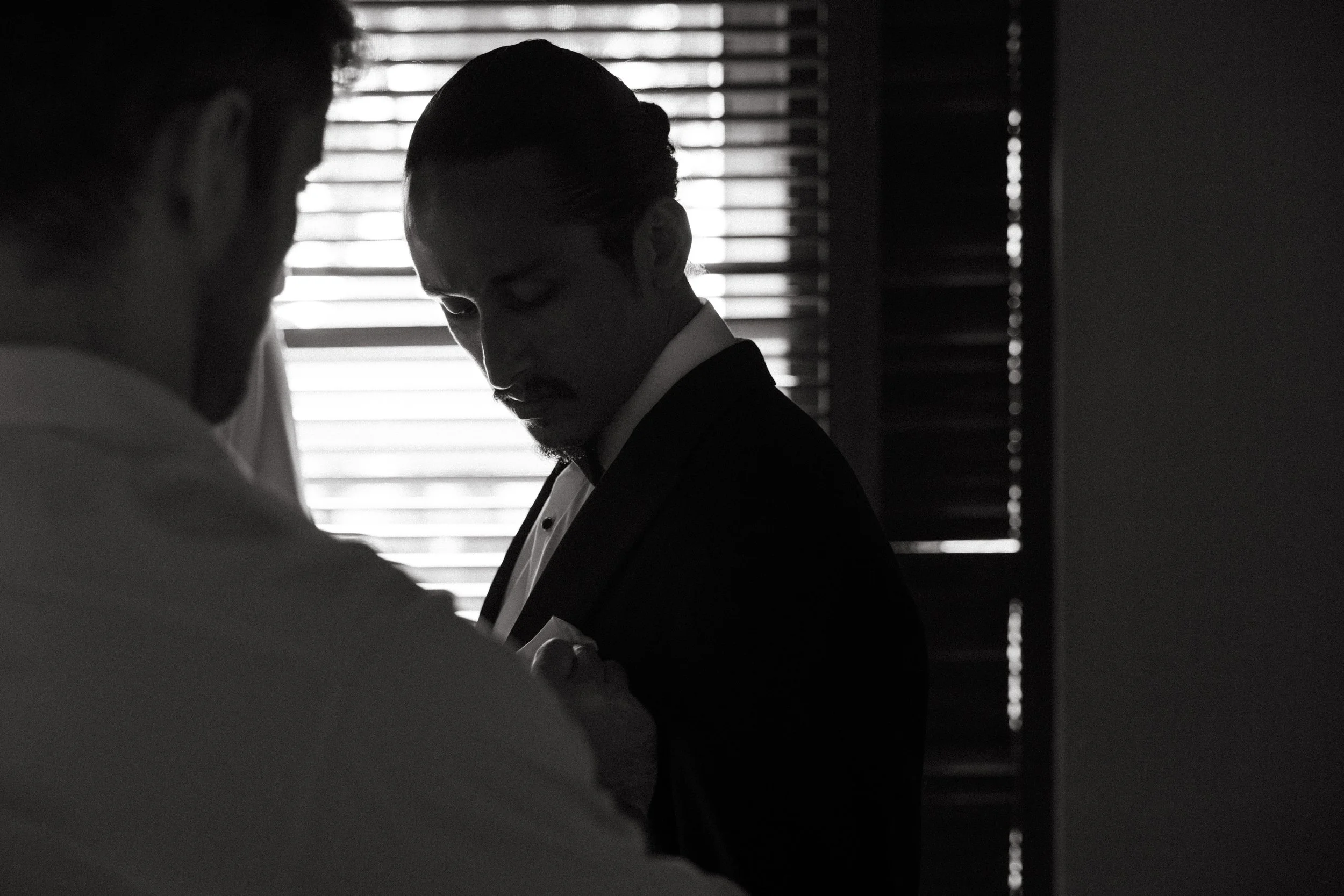 groomsmen helping groom with straightening his boutonniere